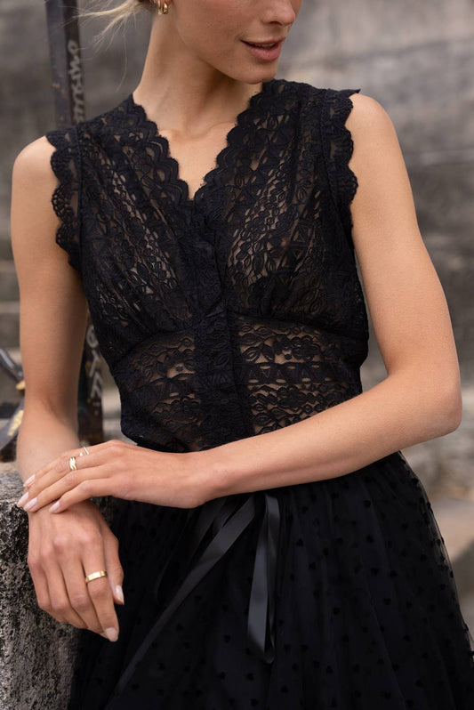Woman wearing a black lace top with a blurred background