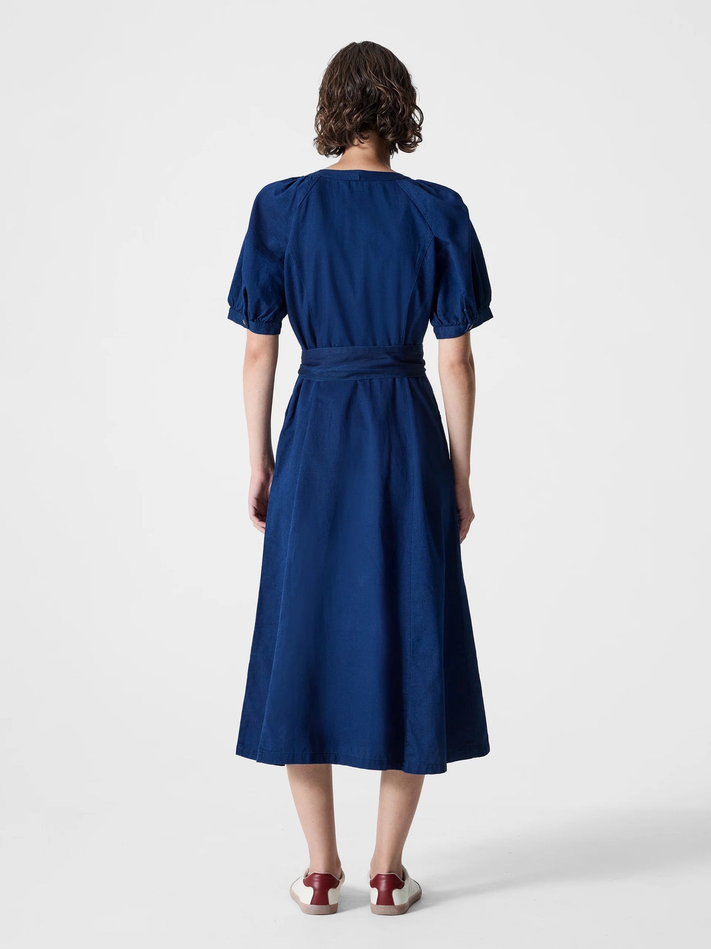 Woman wearing a dark blue maxi button through dress with V -Neck, short sleeves and tie waist.