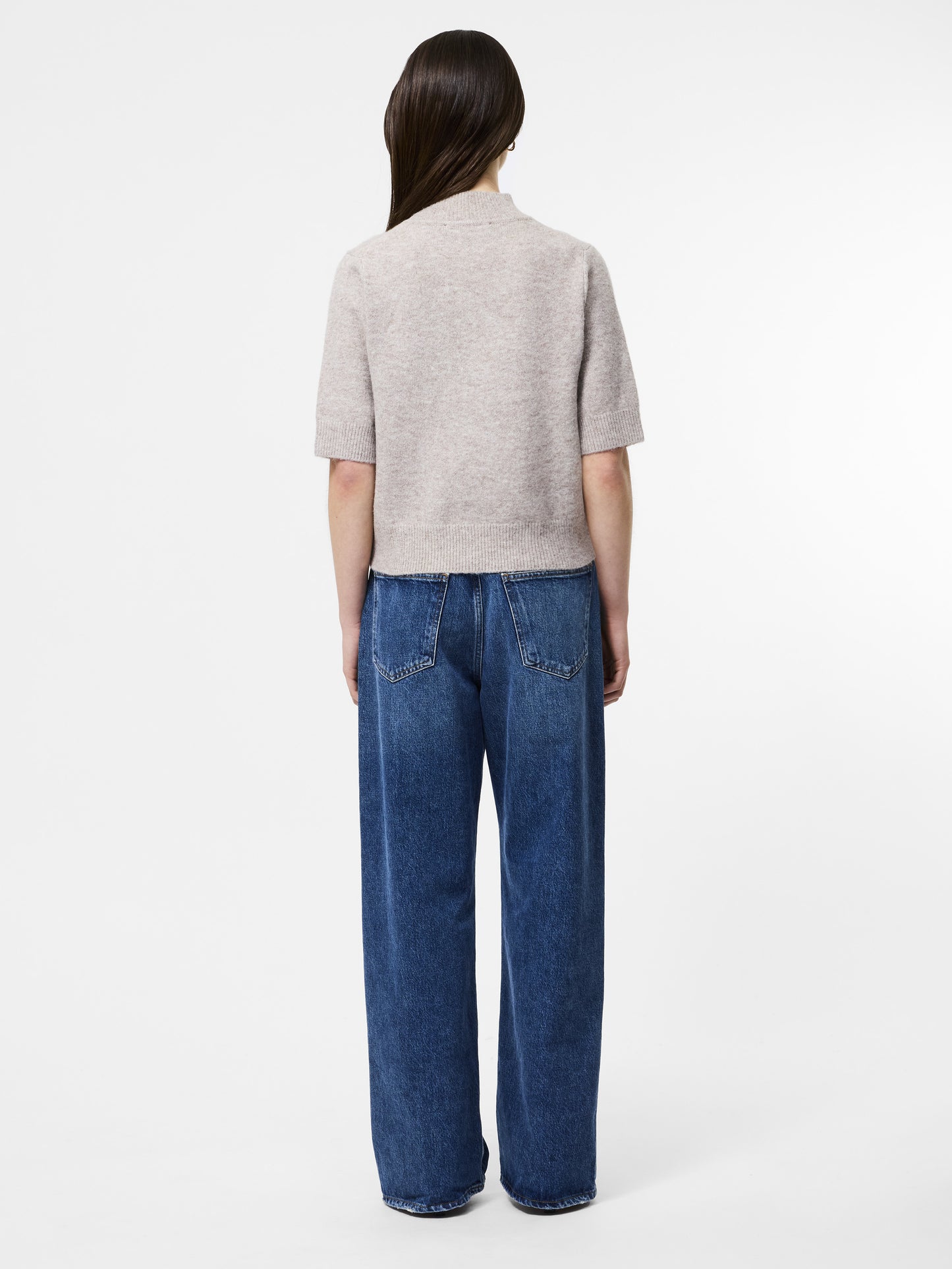 Woman wearing a mock neck almond coloured short sleeved jumper