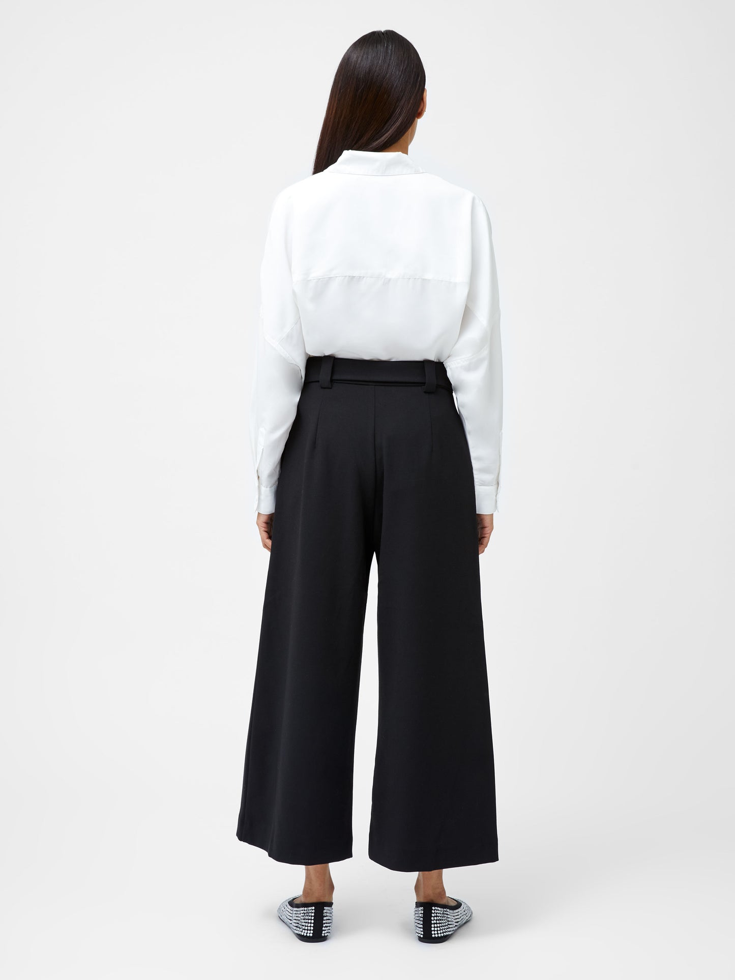 Woman wearing Wide leg belt culottes in black. View is from the back
