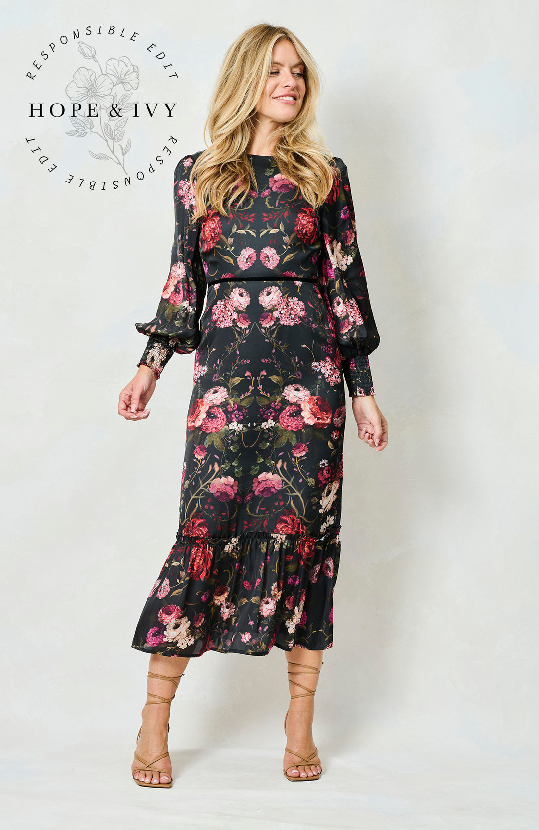 Woman wearing the Holly floral dress with long sleeves on a white background, featuring the brand 'Hope & Ivy'.