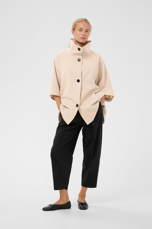 Woman wearing the InWear HollyN beige cape with black buttons on a white background