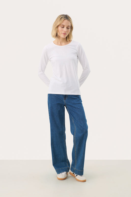 Woman wearing a white long sleeved top and jeans