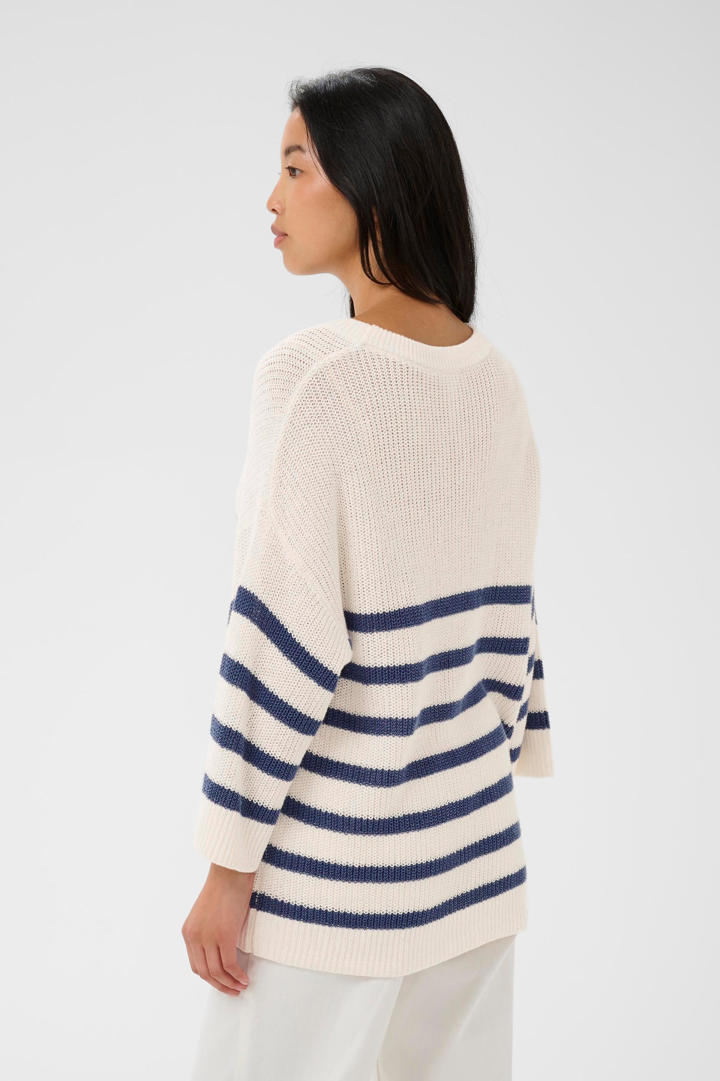 Woman wearing the Part Two Aliza white and navy striped sweater against a plain background