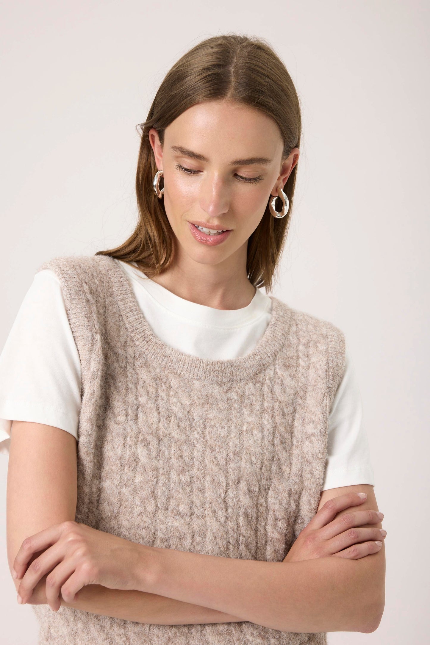Woman wearing the Soaked in Luxury Vespera beige knitted vest over a white shirt.