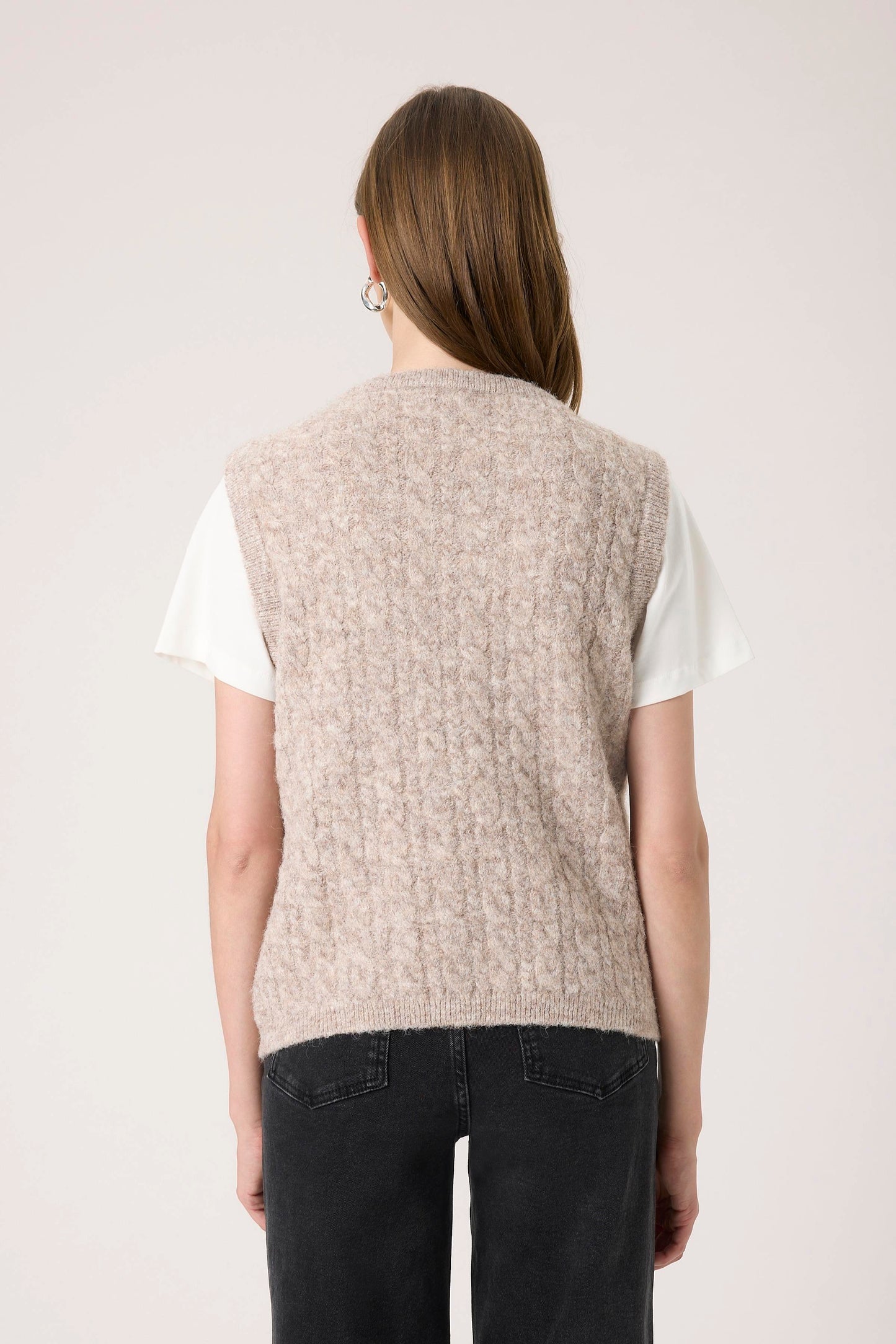 Woman wearing the Soaked in Luxury Vespera beige knitted vest over a white shirt.