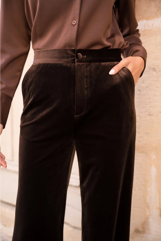 Woman wearing brown straight leg velvet trousers