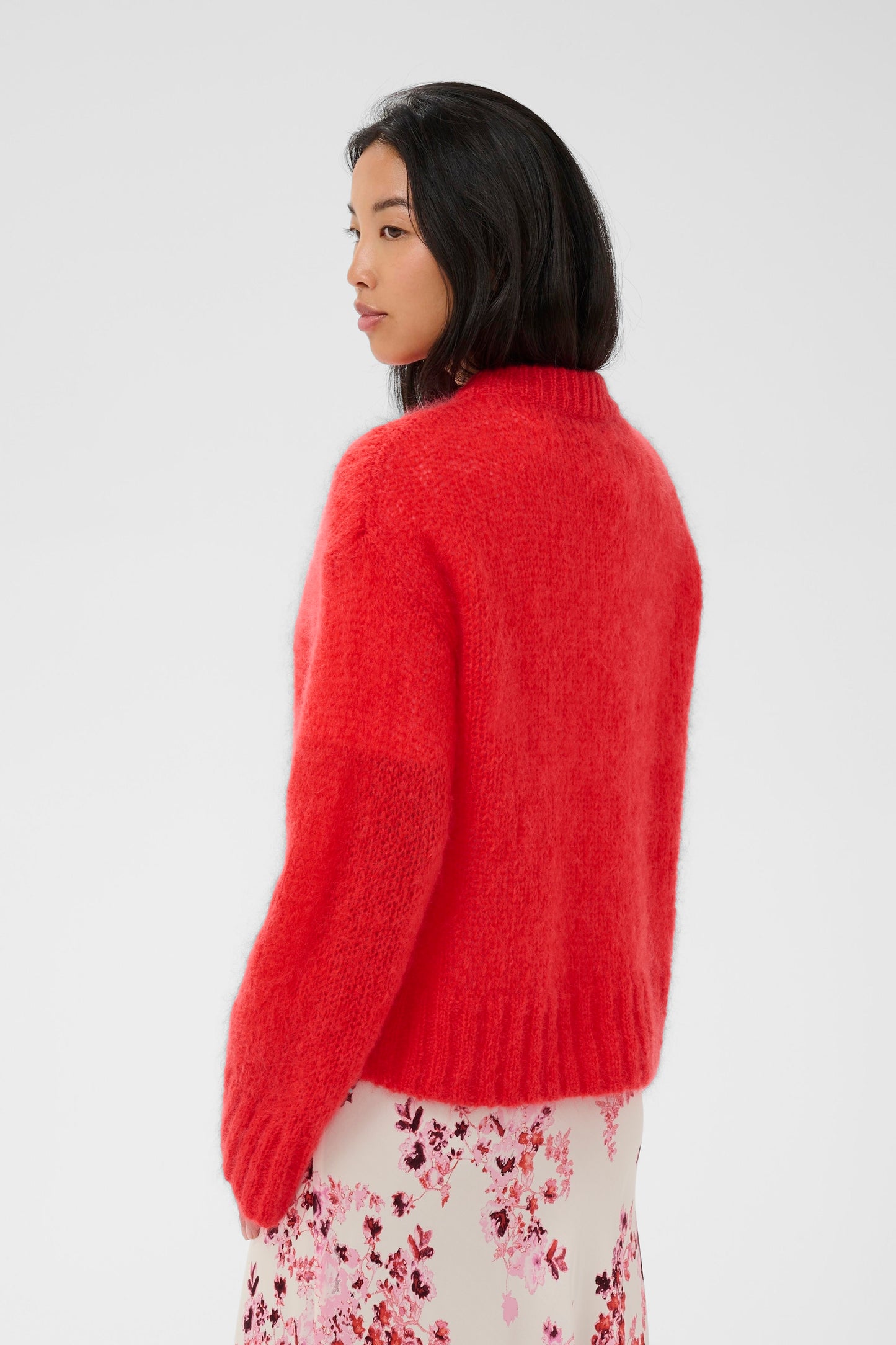 Woman wearing a red sweater on a white background