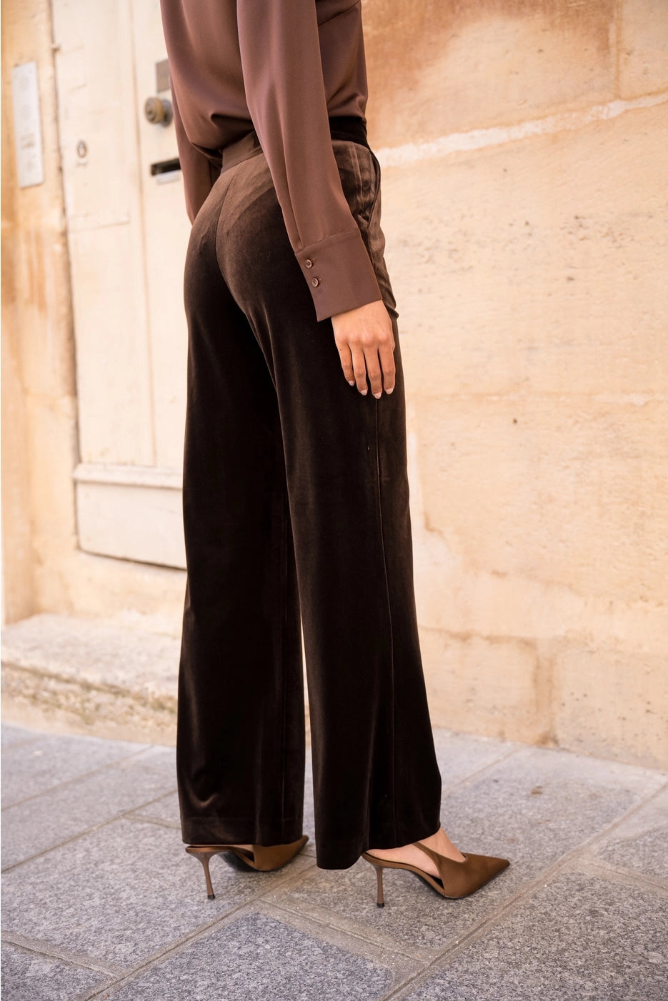 Woman wearing brown straight leg velvet trousers
