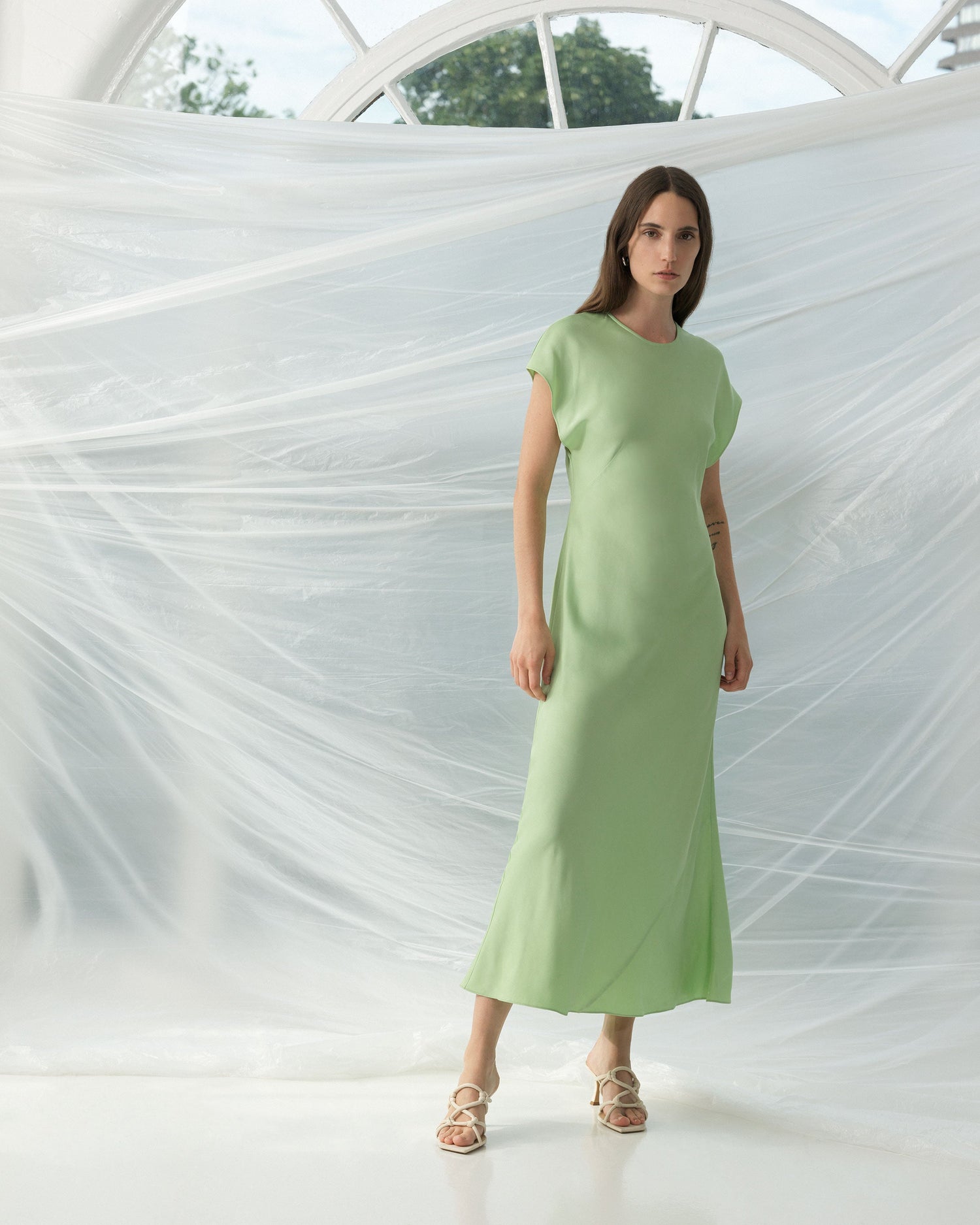 Girl wearing a beautiful fitted apple green satin maxi dress