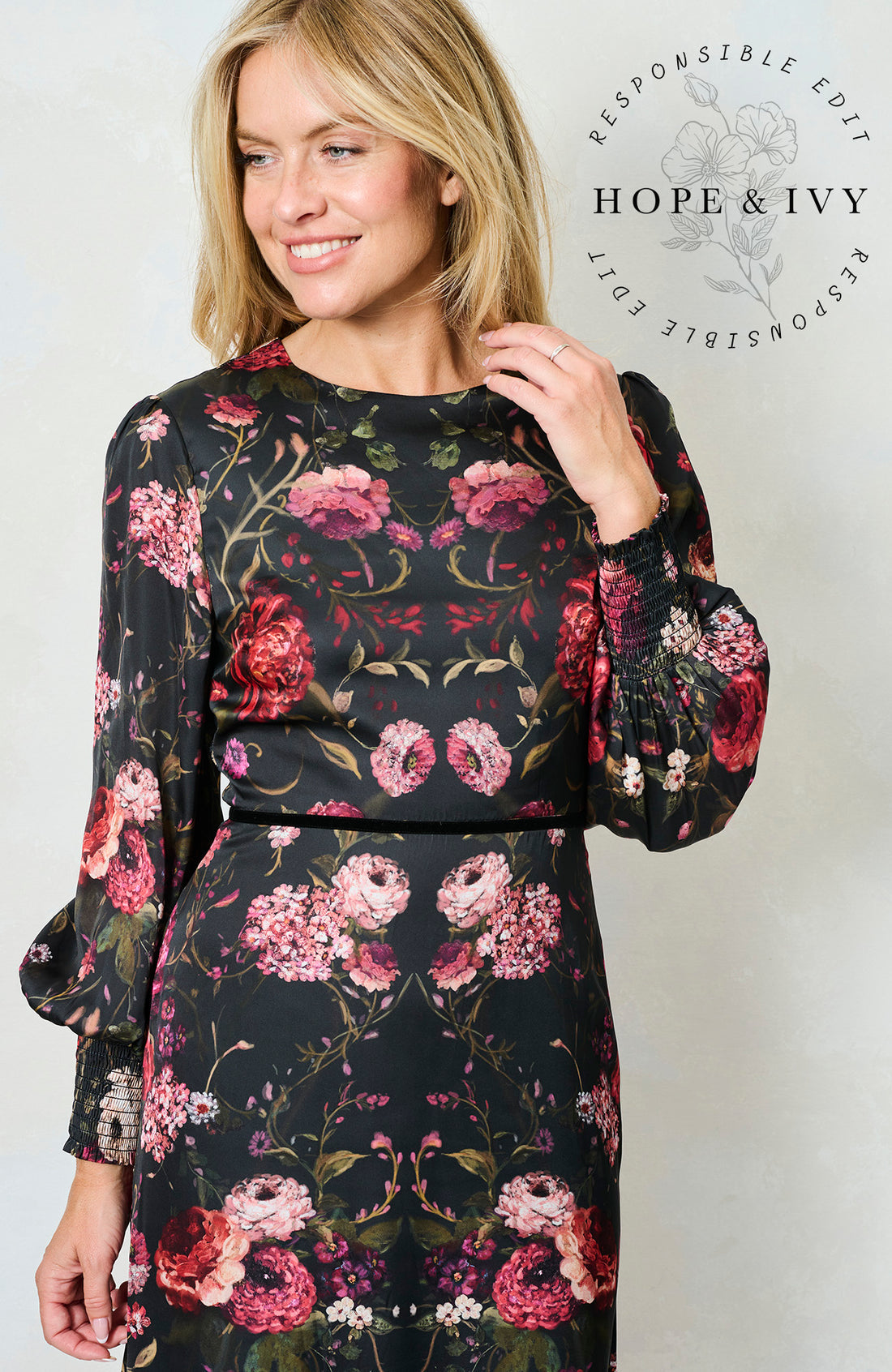 Woman wearing and black dress with a pink floral pattern on it