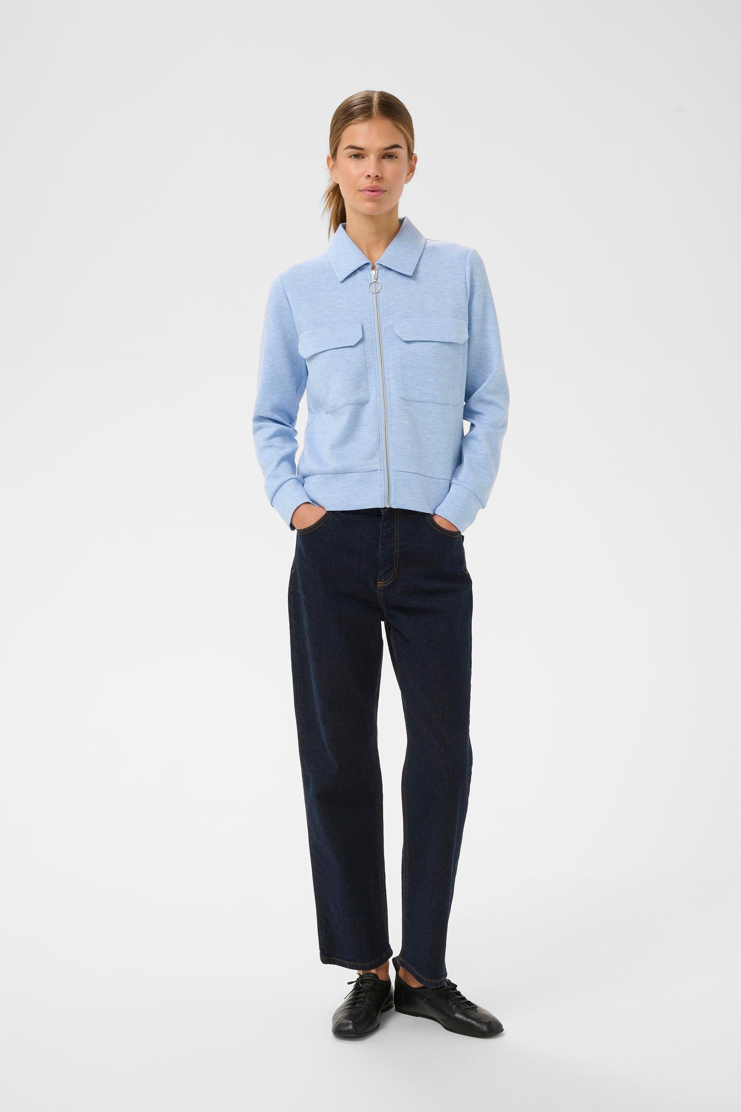 Woman wearing the InWear Beca cardigan with collar, front pockets and zip fastening.  In Endless sky blue colour.