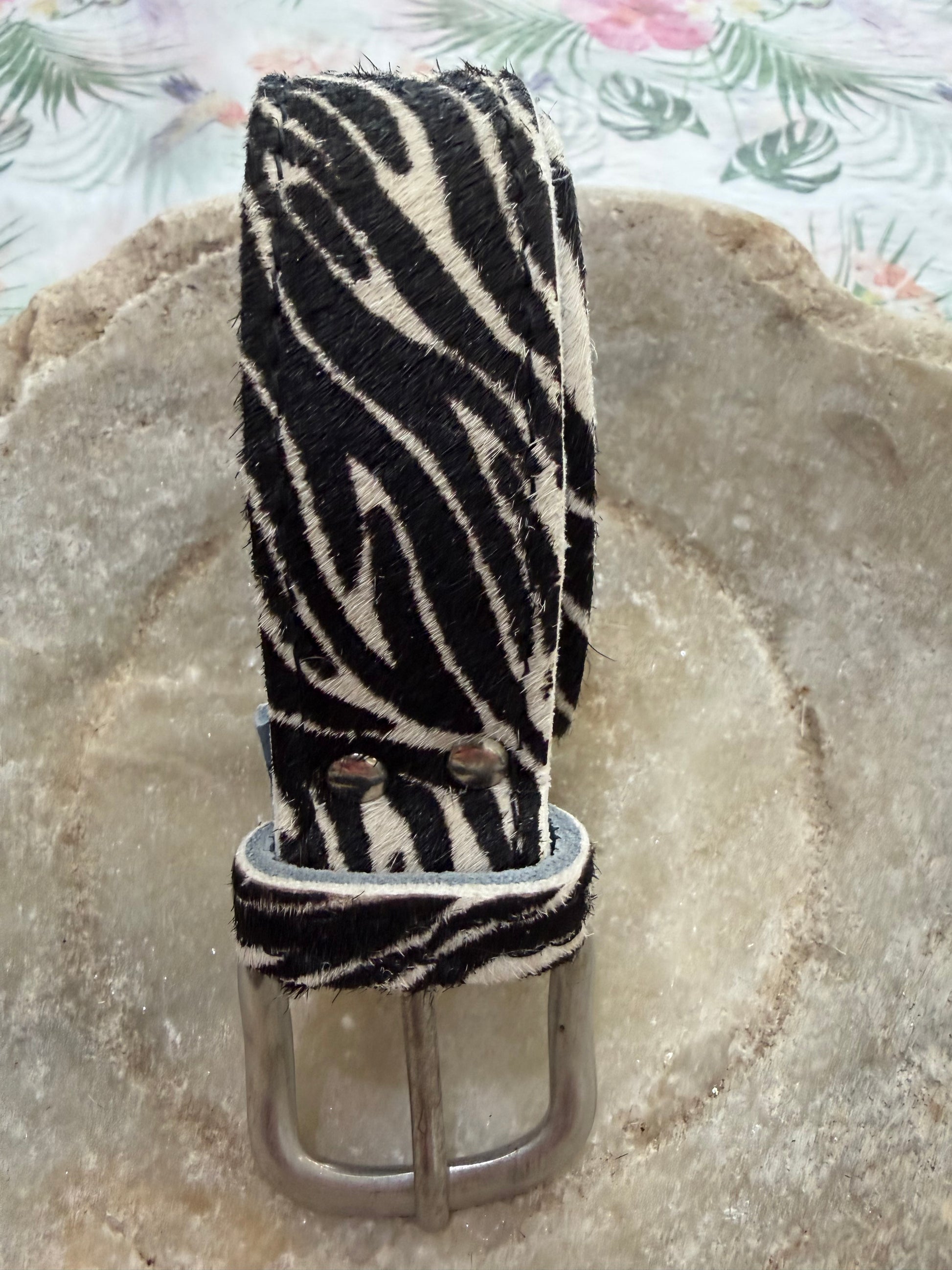 Zebra print belt on a textured stone surface