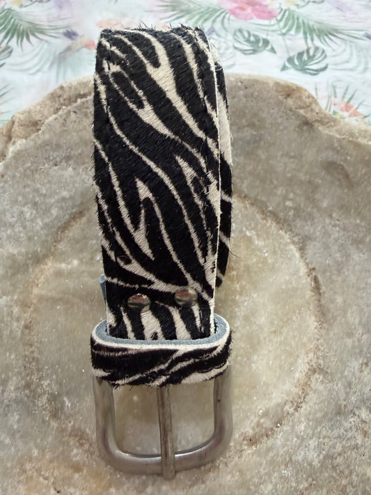 Zebra print belt on a textured stone surface