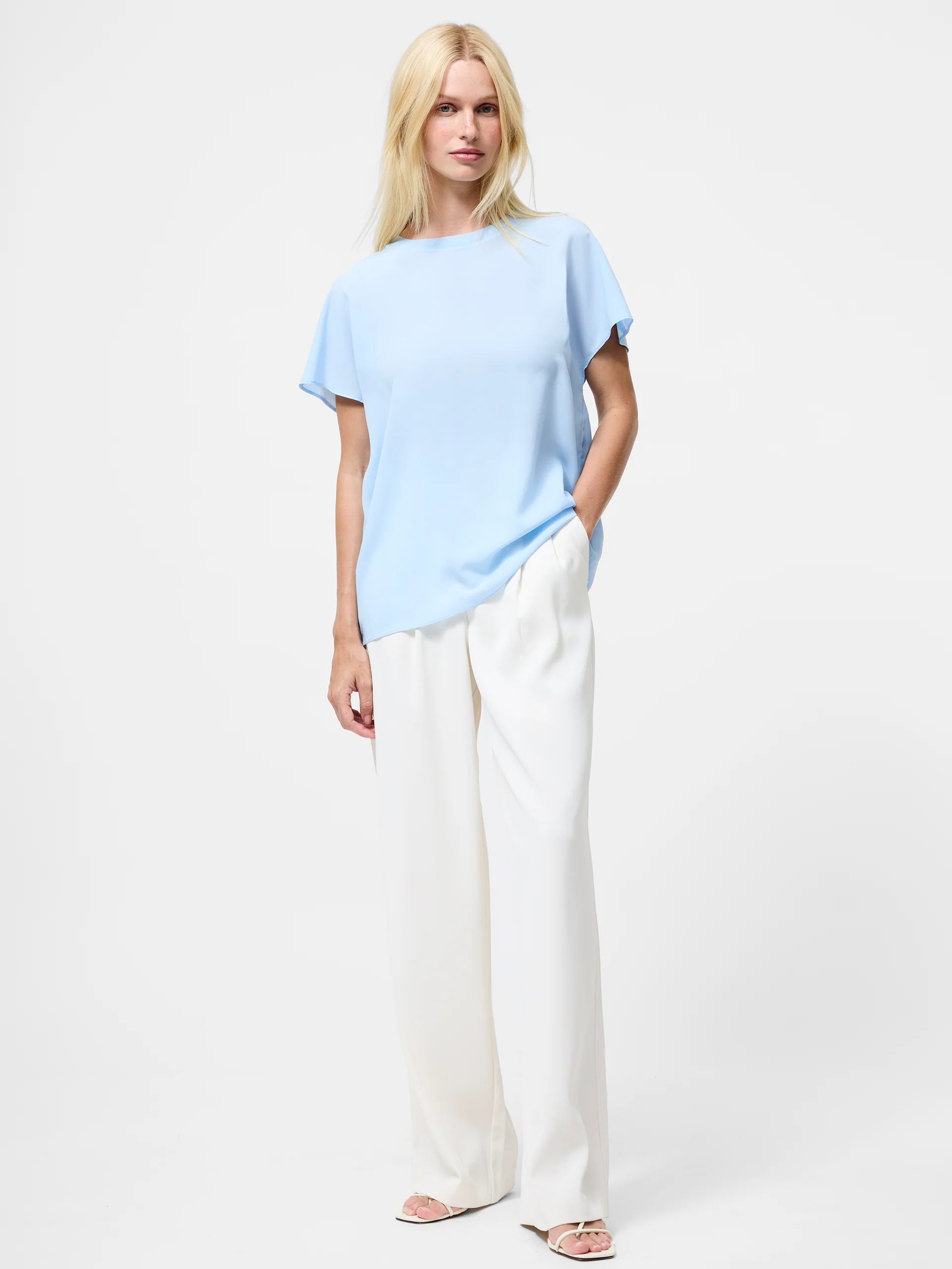Woman wearing a light blue top with short sleeves and crew neck