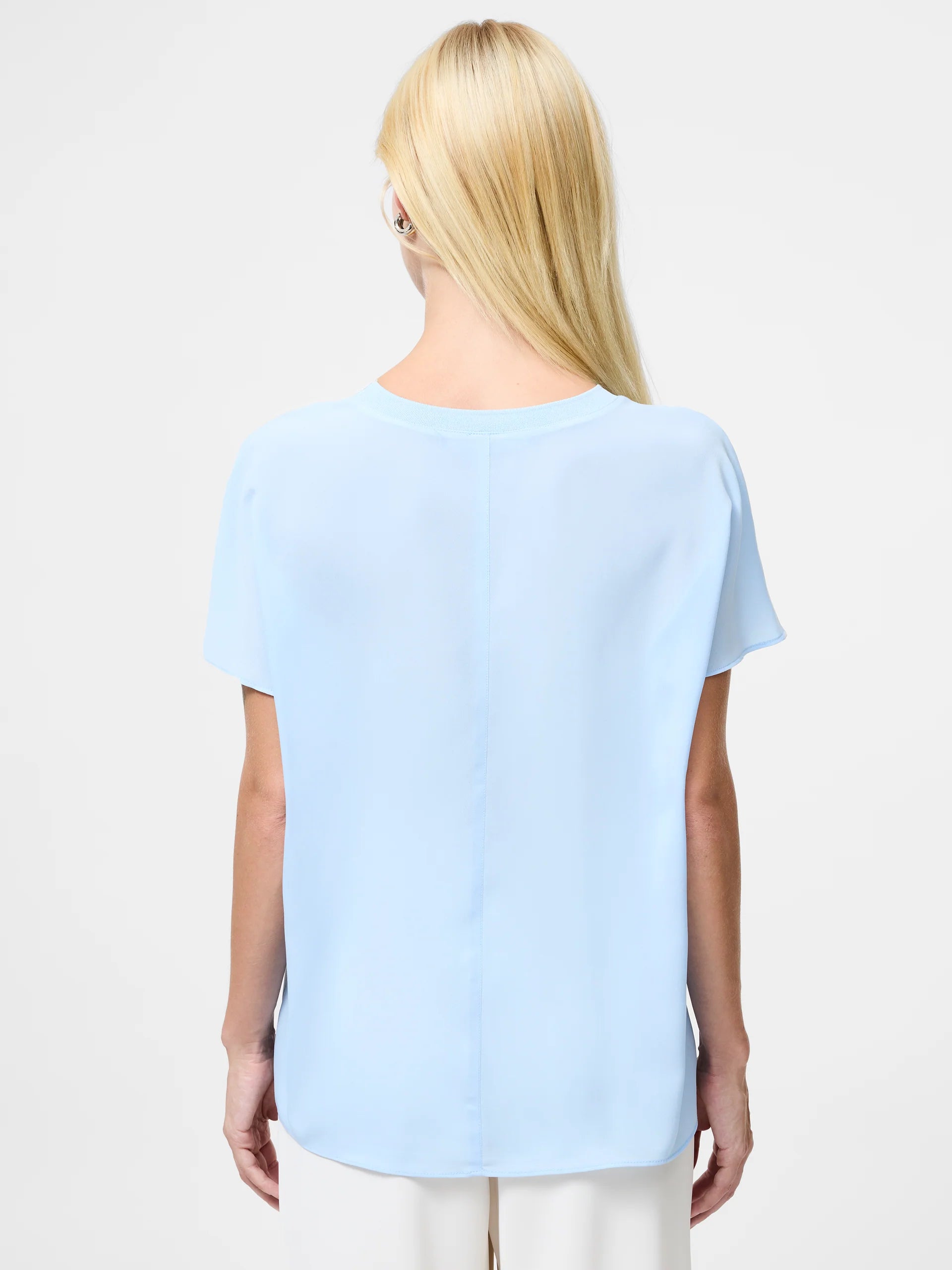 Woman wearing a light blue top with short sleeves and crew neck