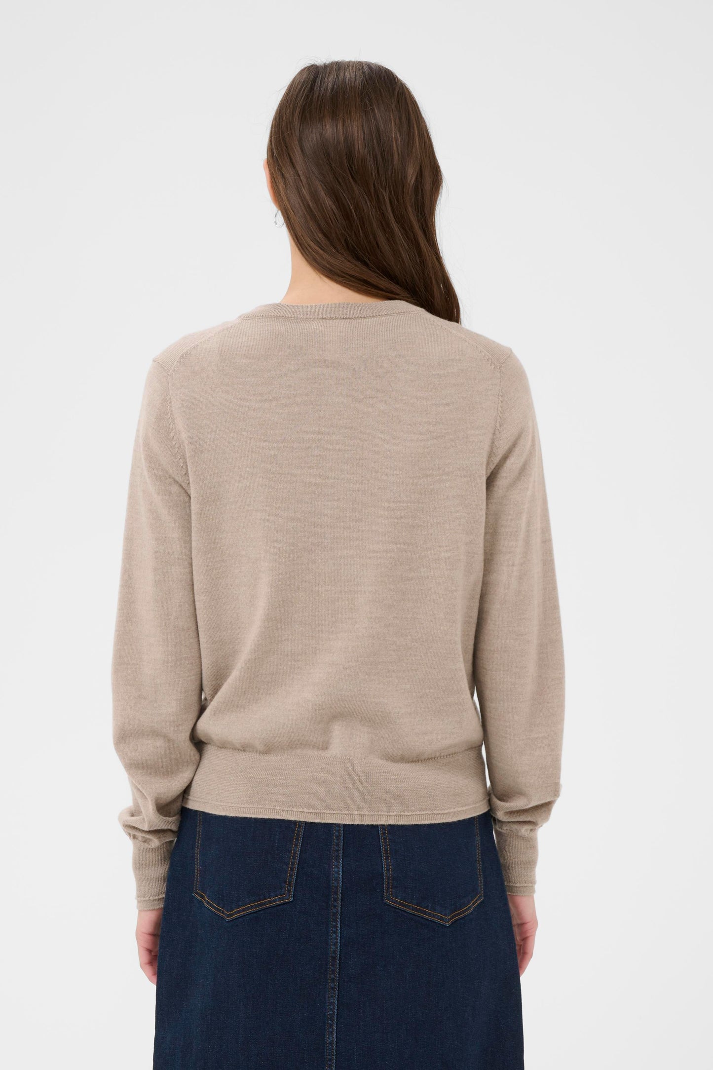 Woman wearing a camel coloured cardigan with a denim skirt