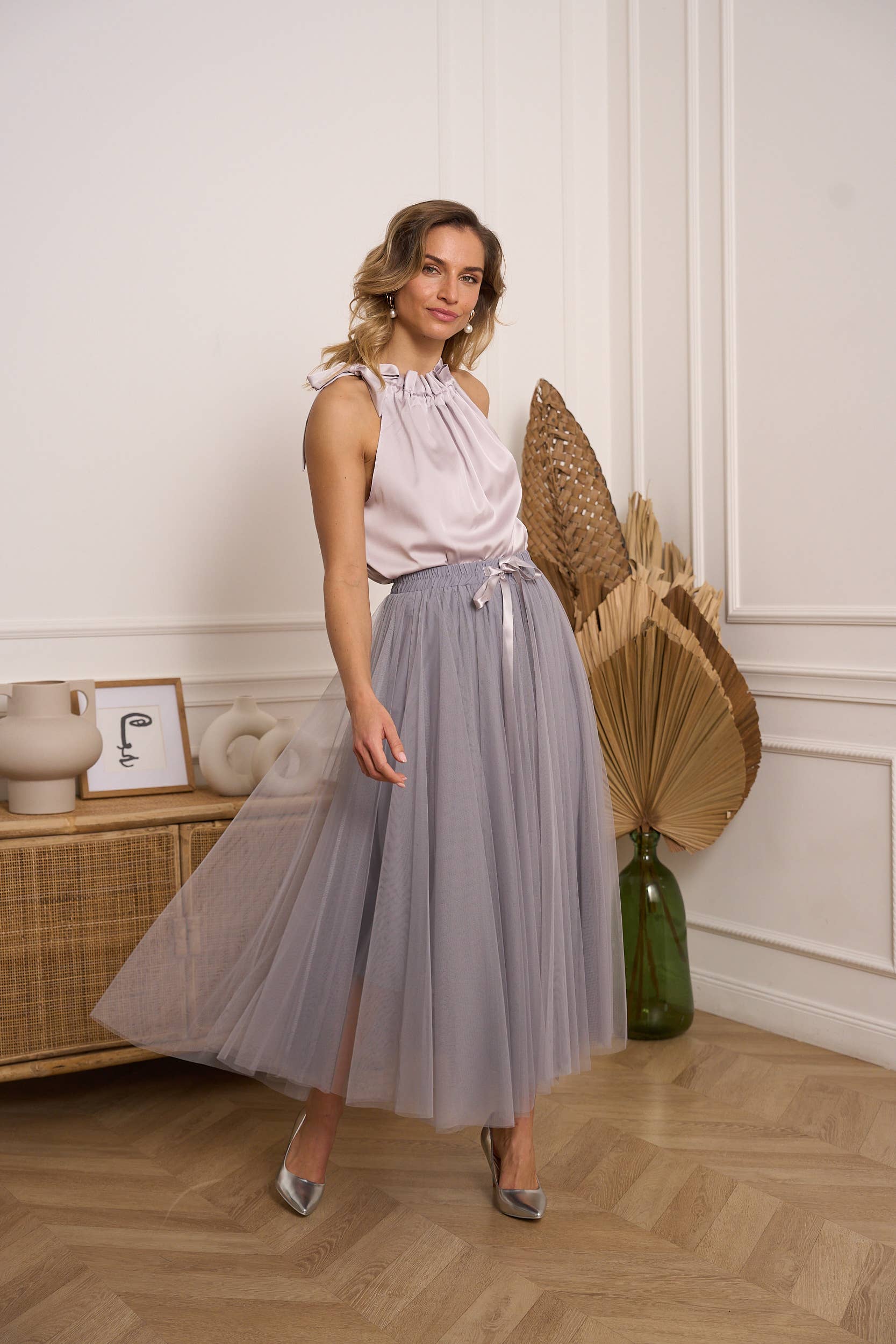 Woman wearing a light grey tulle skirt with a satin top 