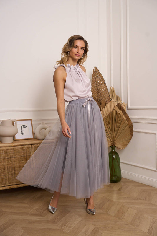 Woman wearing a light grey tulle skirt with a satin top 