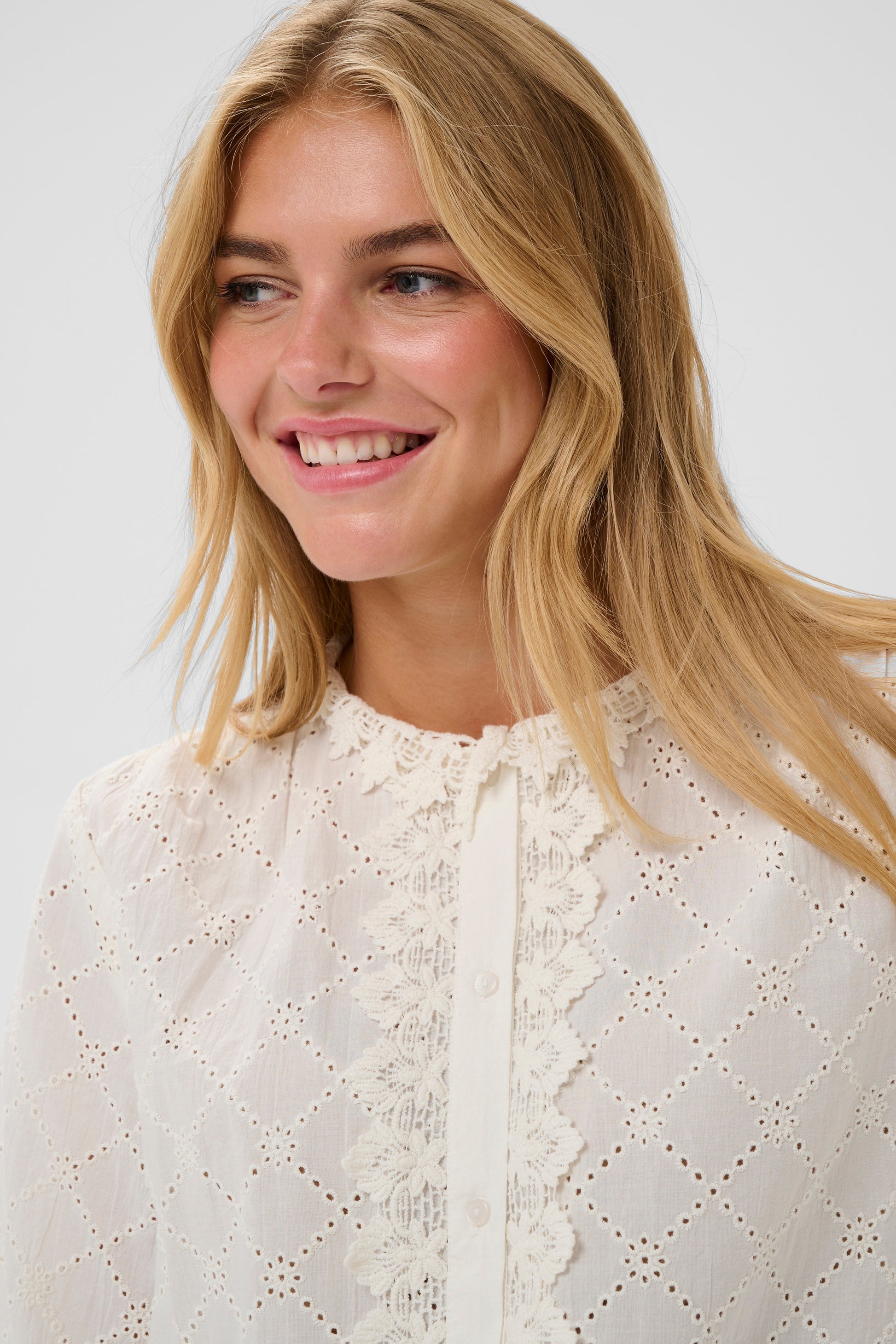 Woman wearing a the Petunia white broderie anglaise blouse 