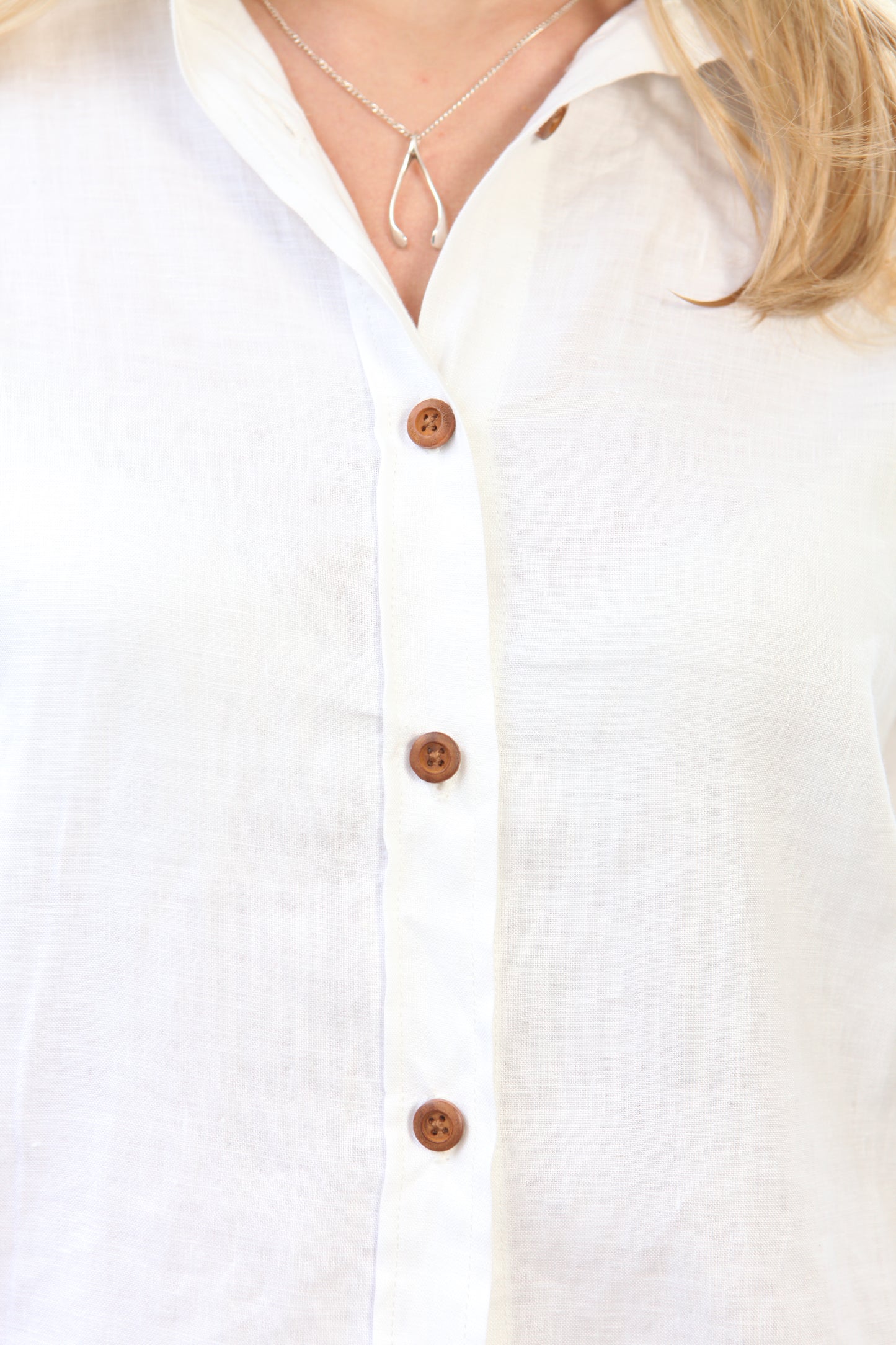 Woman wearing the Dear Prudence White Freddie Shirt in 100% European flax linen with bamboo buttons and a relaxed longer back.