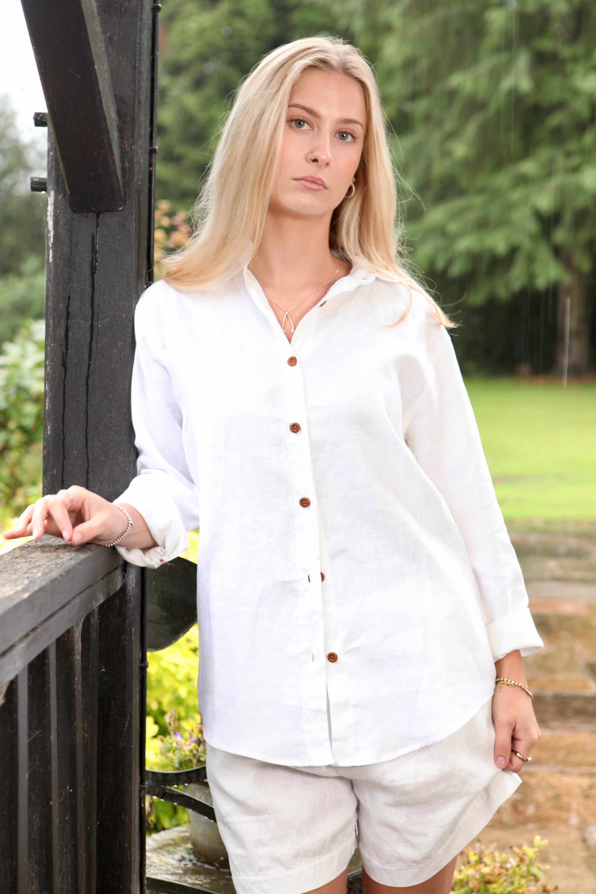 Woman wearing the Dear Prudence White Freddie Shirt in 100% European flax linen with bamboo buttons and a relaxed longer back.