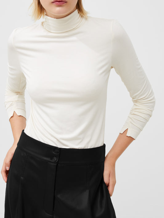 Woman Wearing a cream polo neck top with splits in the cuff