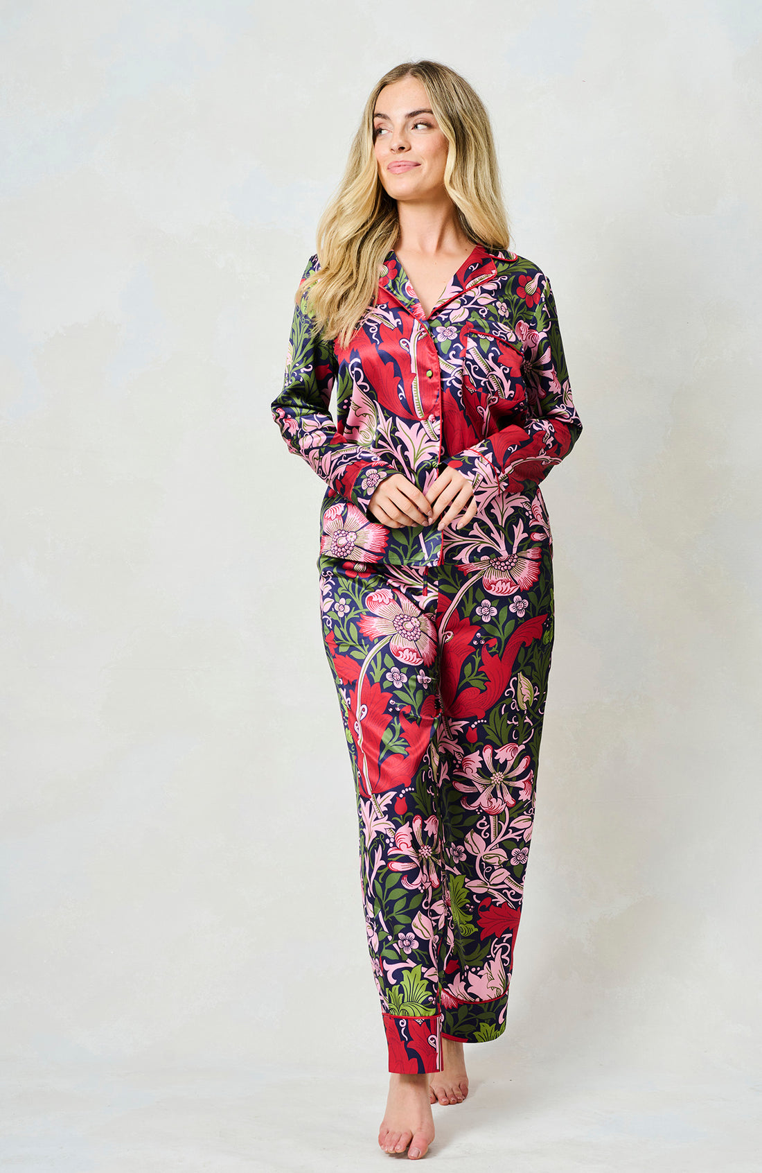 Woman wearing the floral  Marianna satin pyjamas by Hope and Ivy.  In blue, green and pink colours
