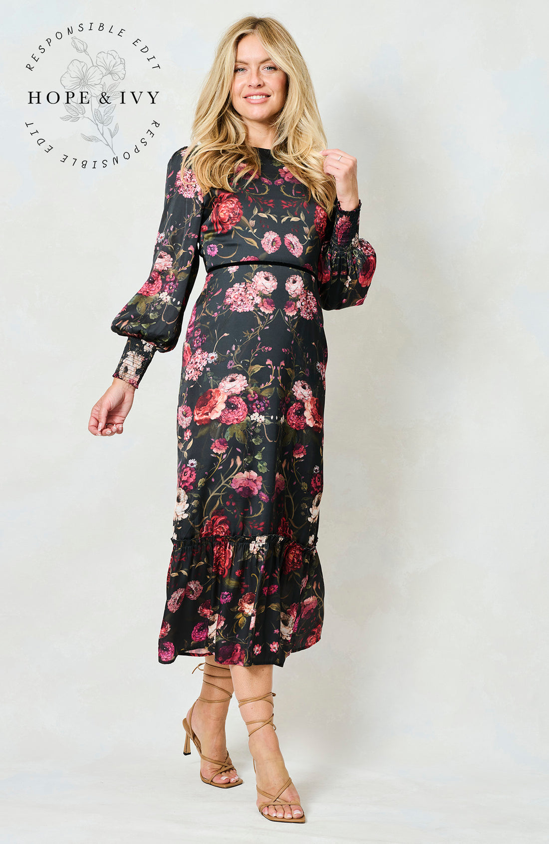 Woman wearing the Holly floral dress with long sleeves on a white background, featuring the brand 'Hope & Ivy'.