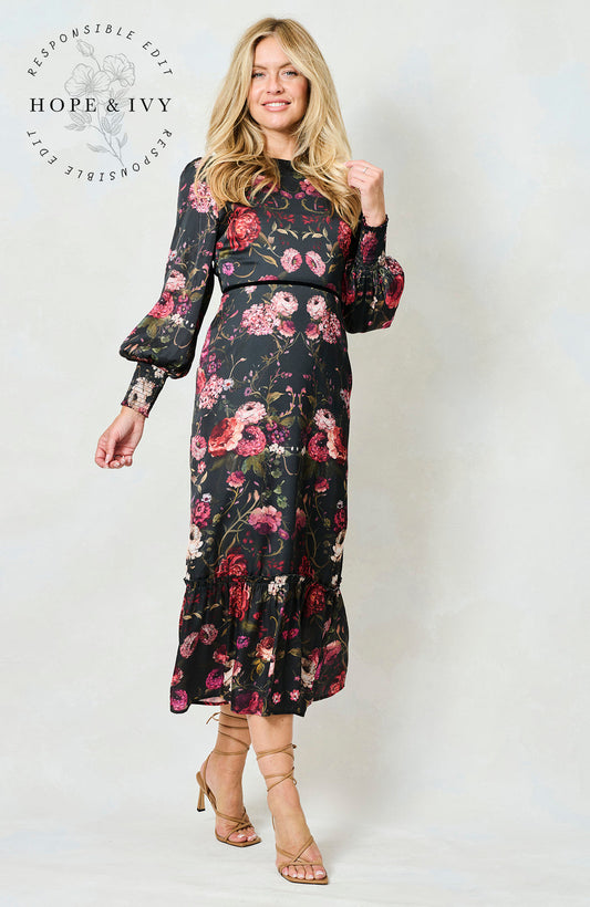 Woman wearing the Holly floral dress with long sleeves on a white background, featuring the brand 'Hope & Ivy'.