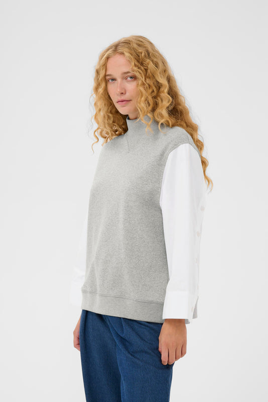Woman wearing the InWear Capella light grey sleeveless sweater with white shirt sleeves.  All in one piece.