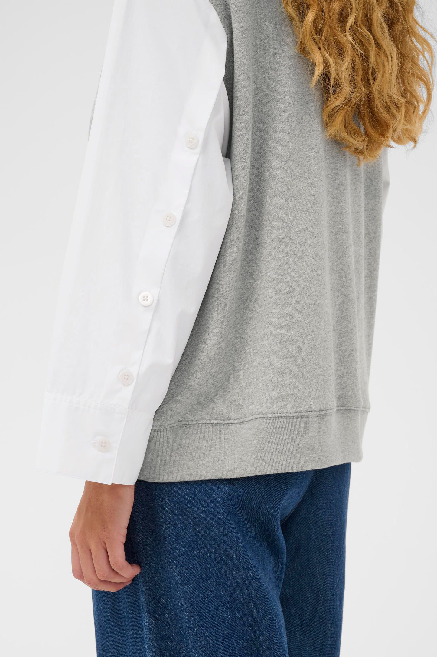Woman wearing the InWear Capella light grey sleeveless sweater with white shirt sleeves.  All in one piece.