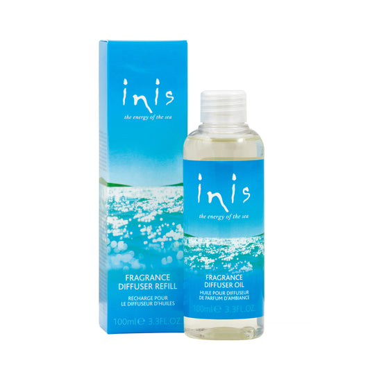 A bottle of Inis fragrance diffuser refill oil next to its packaging box. The packaging is predominantly blue with the brand 'Inis' visible on both the bottle and the box.