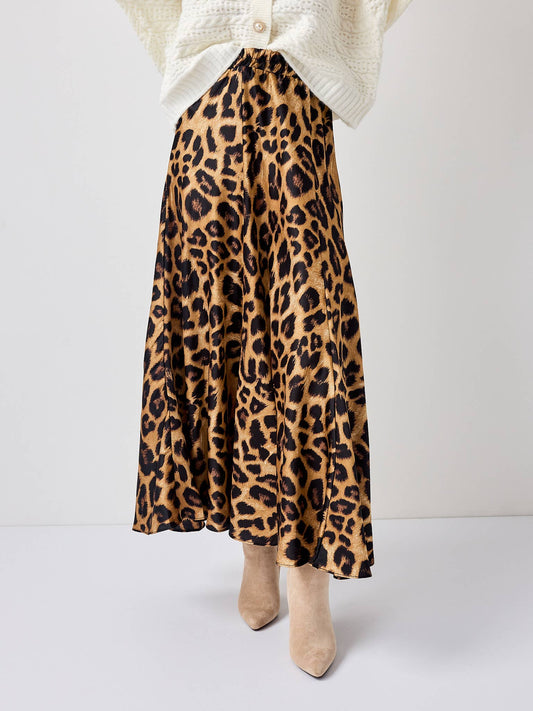 Leopard print skirt worn with a white sweater on a plain background
