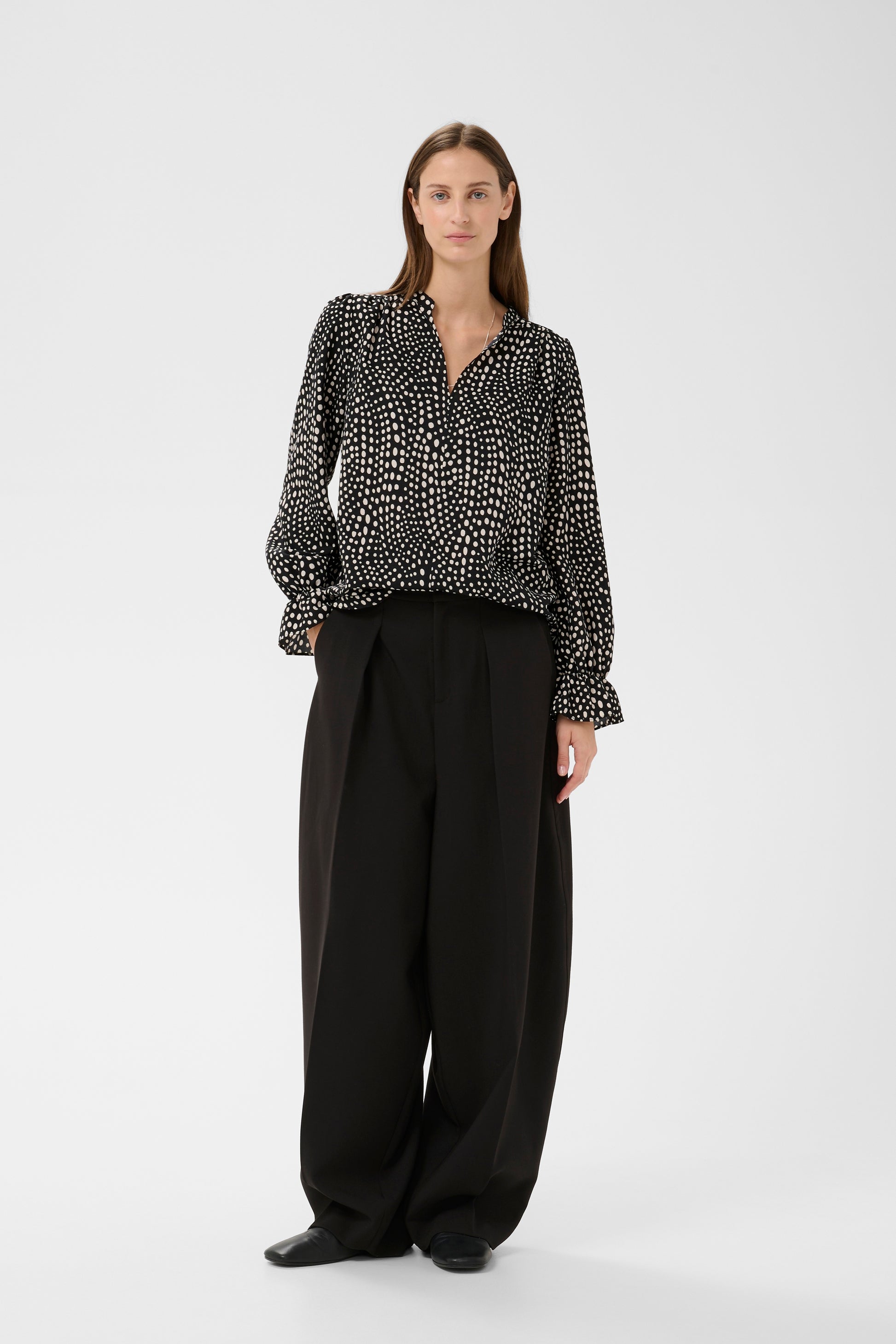 Woman wearing the Inwear Liberty black blouse with white dots on it