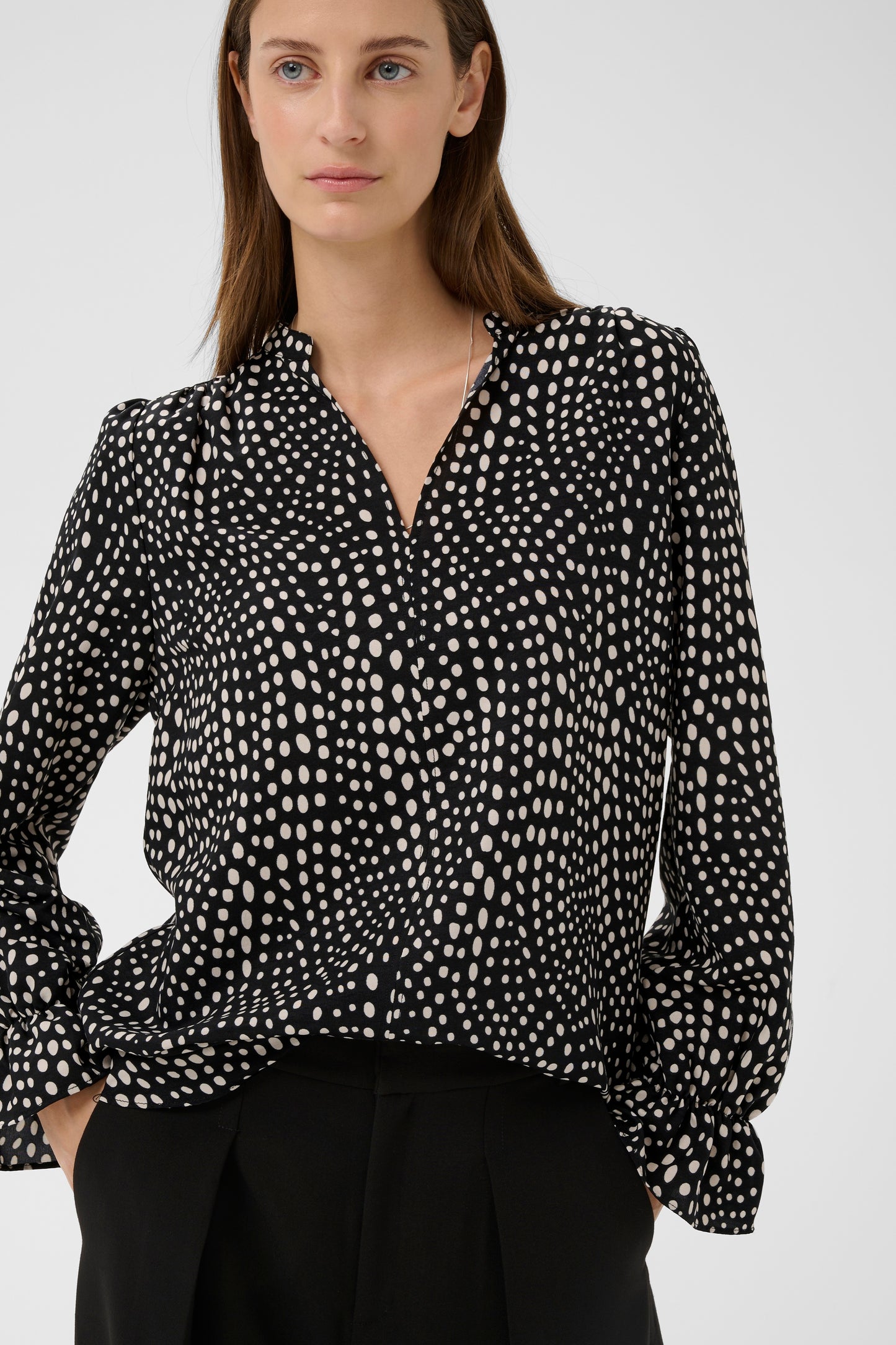 Woman wearing the Inwear Liberty black blouse with white dots on it