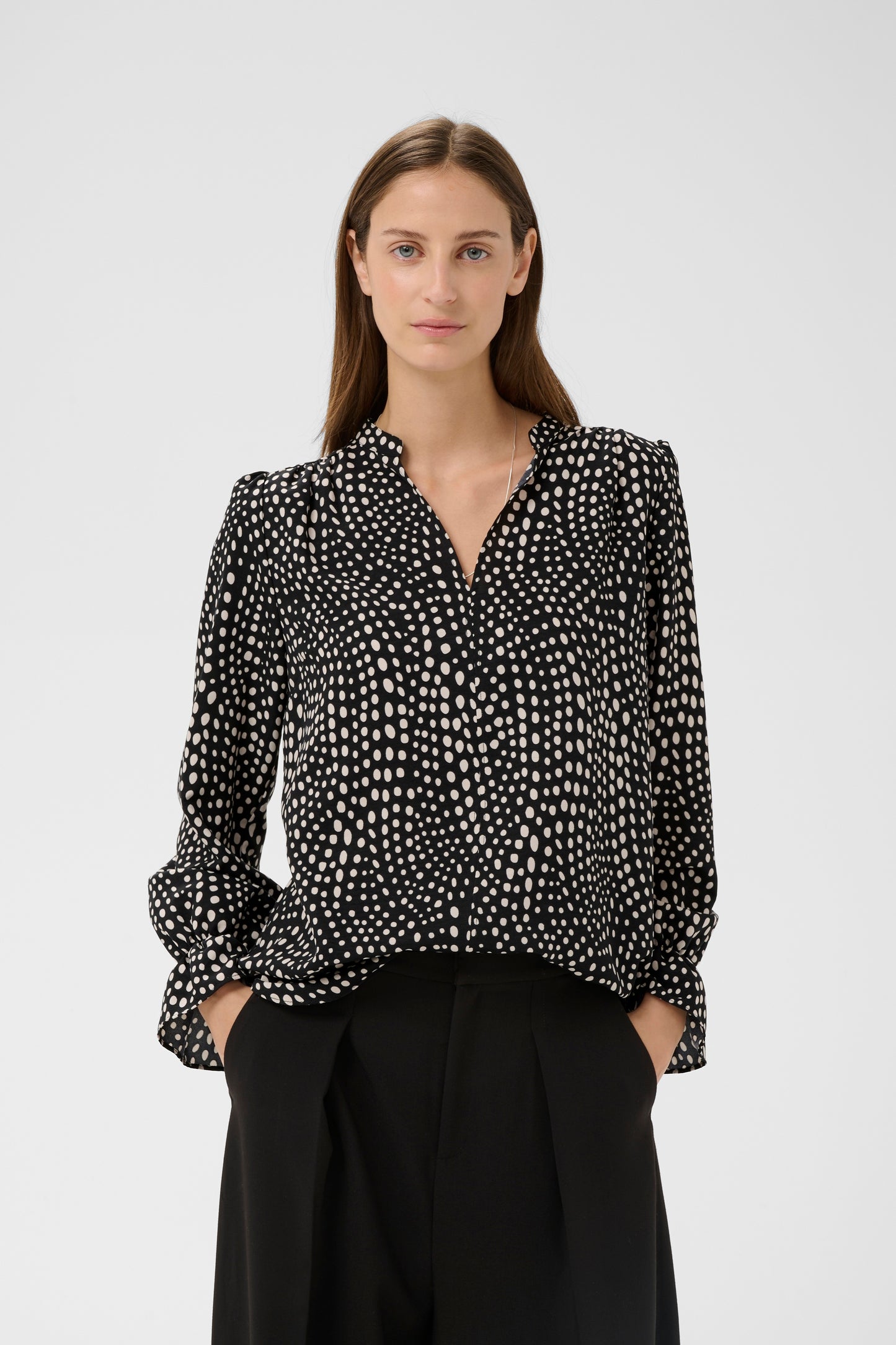 Woman wearing the Inwear Liberty black blouse with white dots on it