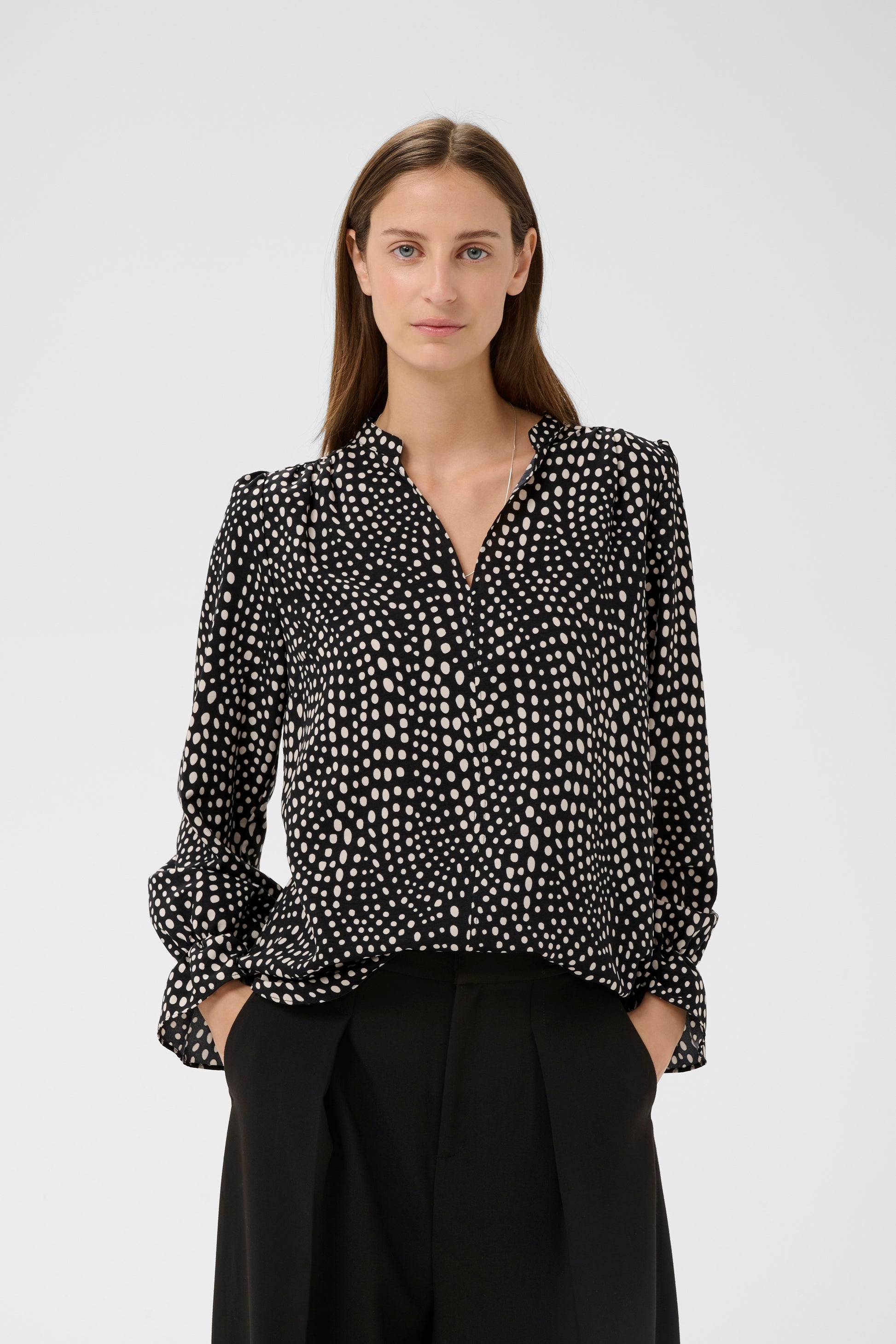 Woman wearing the Inwear Liberty black blouse with white dots on it