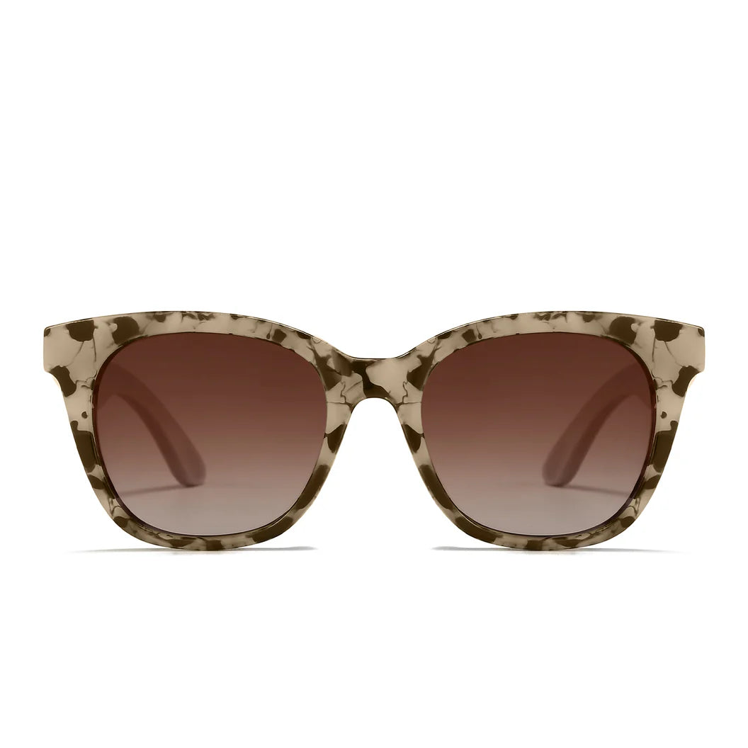 Sunglasses with tortoiseshell frame and brown gradient lenses, accompanied by a wooden arm on a white background.