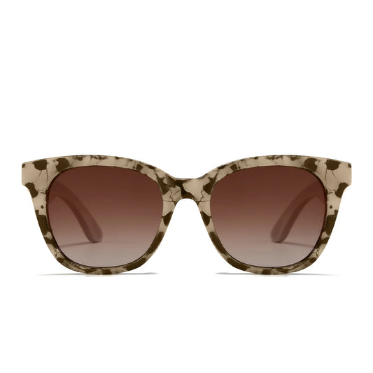 Sunglasses with tortoiseshell frame and brown gradient lenses, accompanied by a wooden arm on a white background.