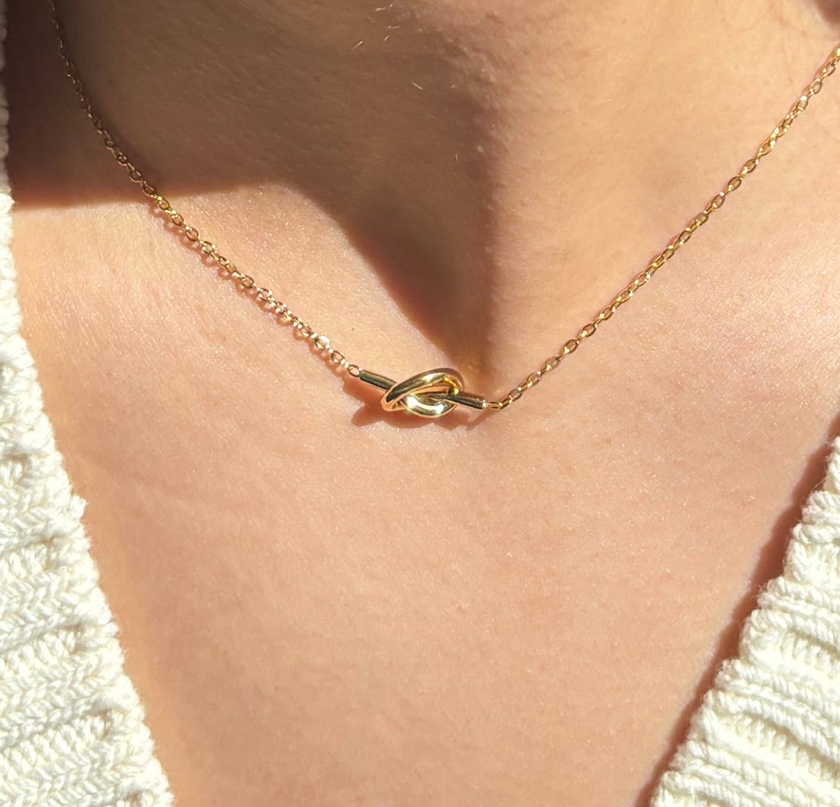 Gold necklace with a unique clasp on a person's neck