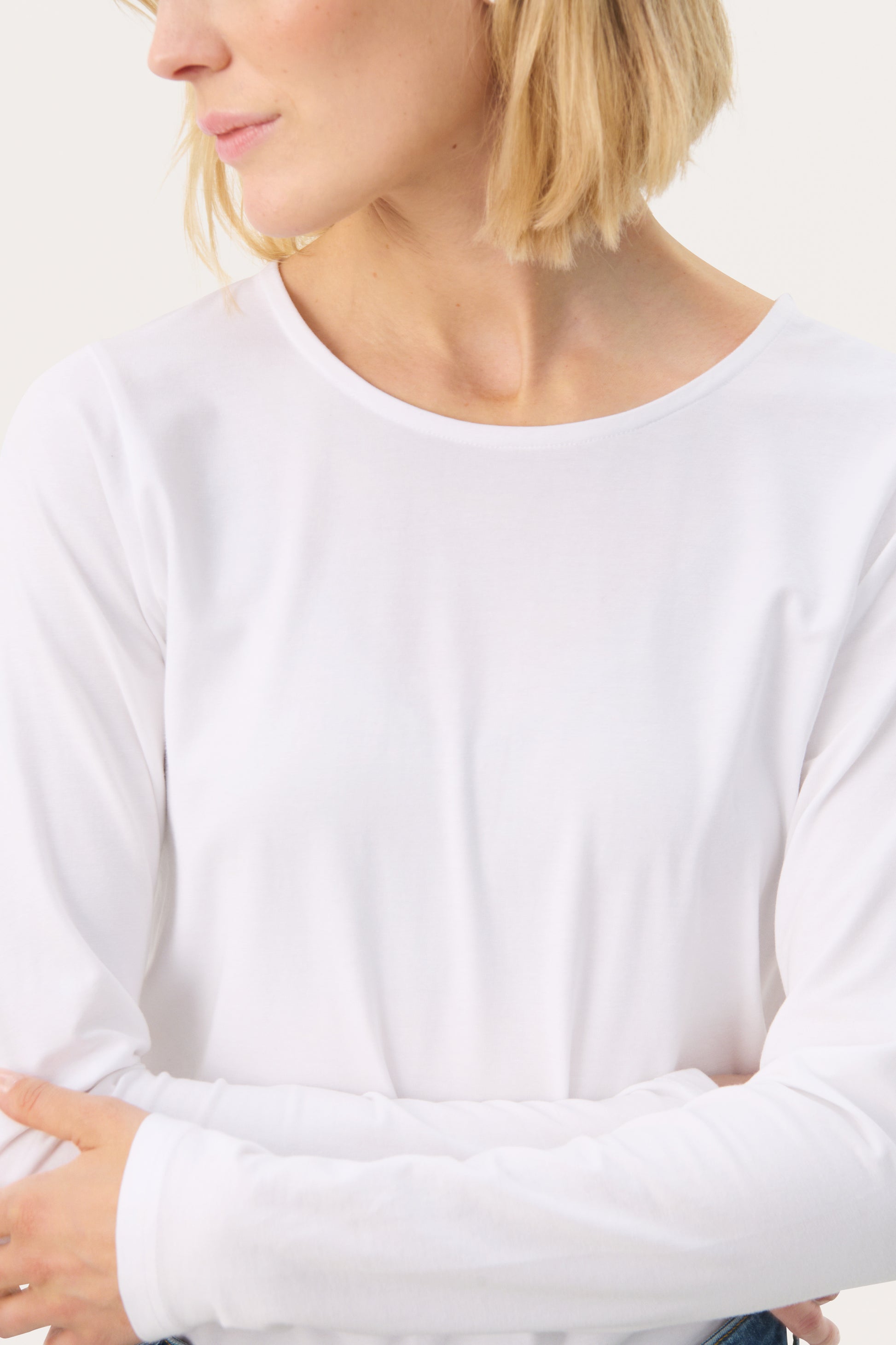 Woman wearing a white long sleeved top and jeans