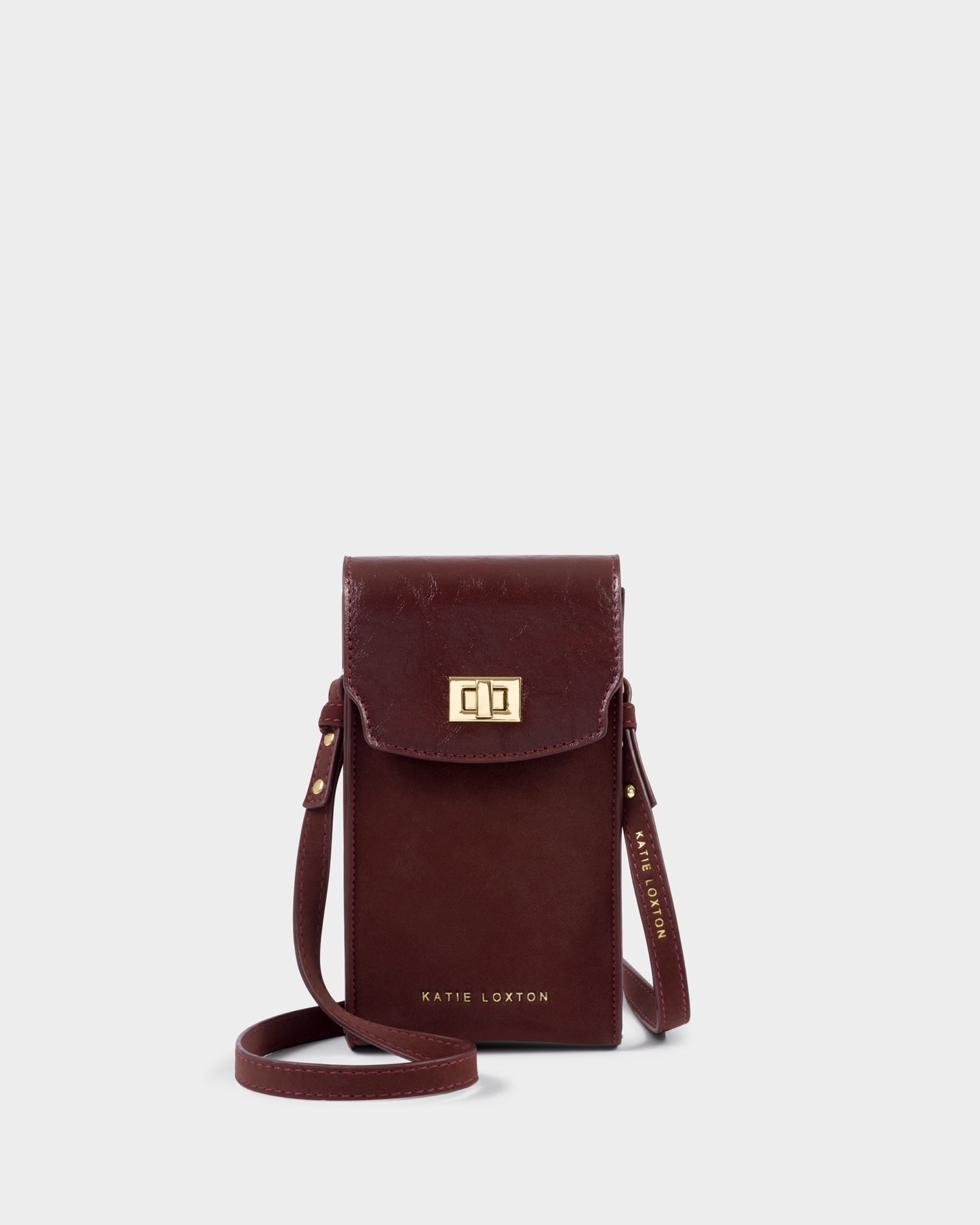 Katie Loxton Orin Twist Lock Slim Bag in cherry with gold twist lock fastening and adjustable crossbody strap.