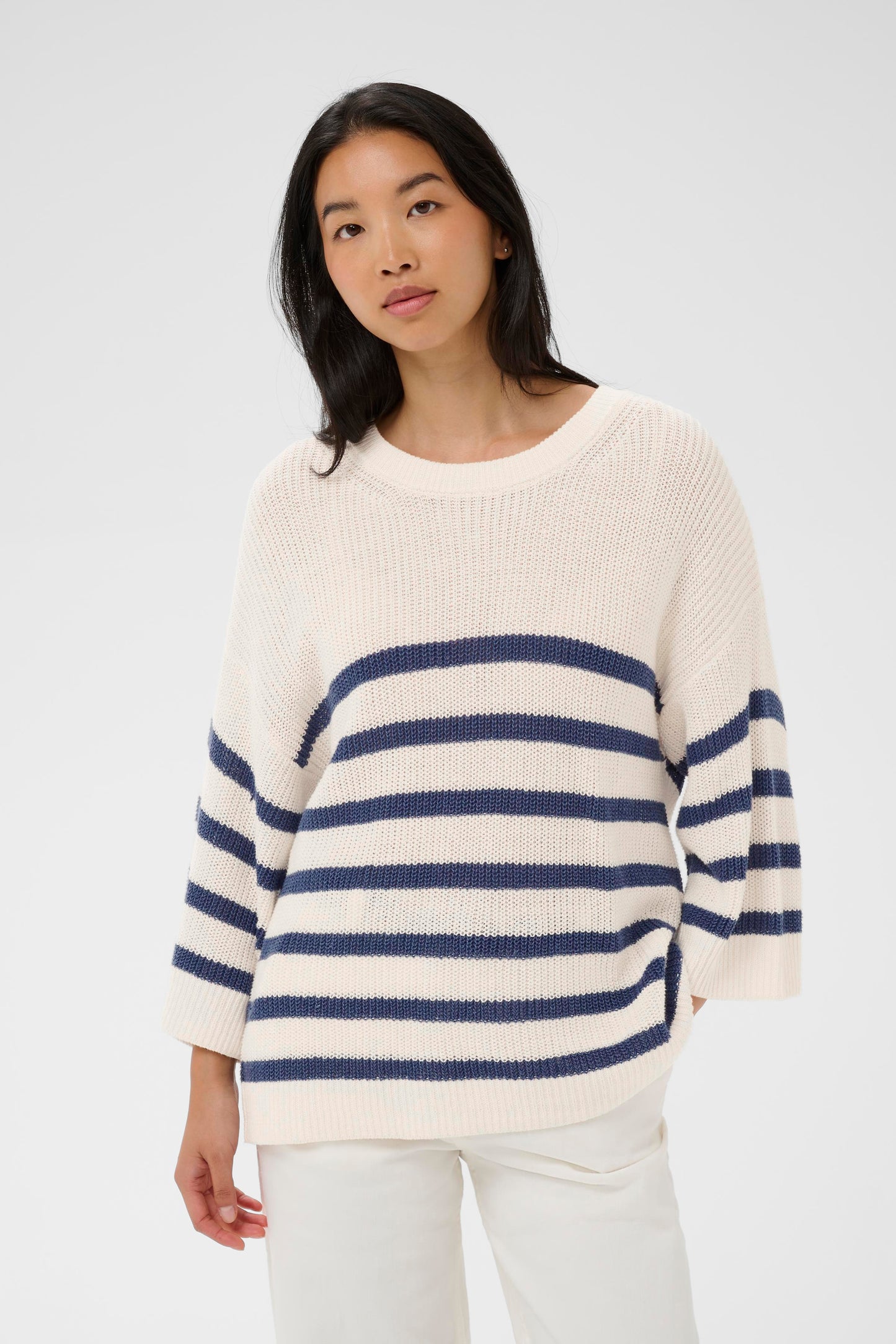 Woman wearing the Part Two Aliza white and navy striped sweater against a plain background