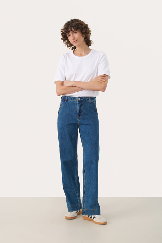 Woman wearing straight leg jeans in a medium blue wash with a white t-shirt