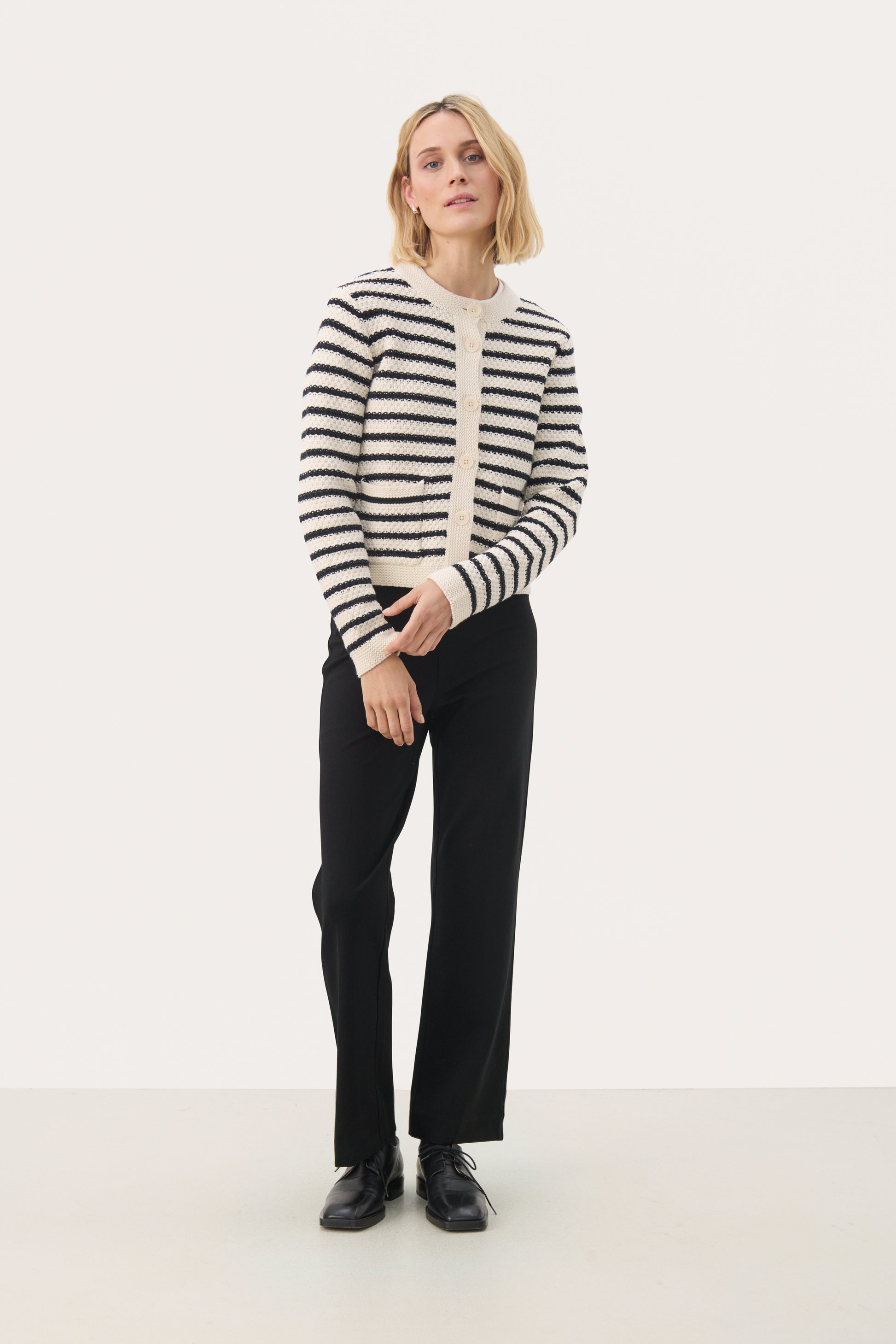 Woman wearing the Part Two Elmie cardigan in a dark navy stripe