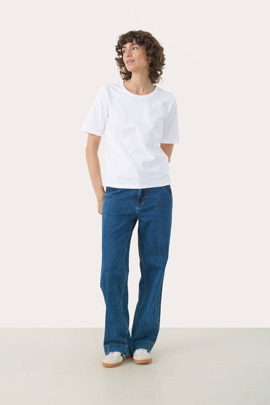 Person wearing the part two ratana white t-shirt and blue jeans on a white background