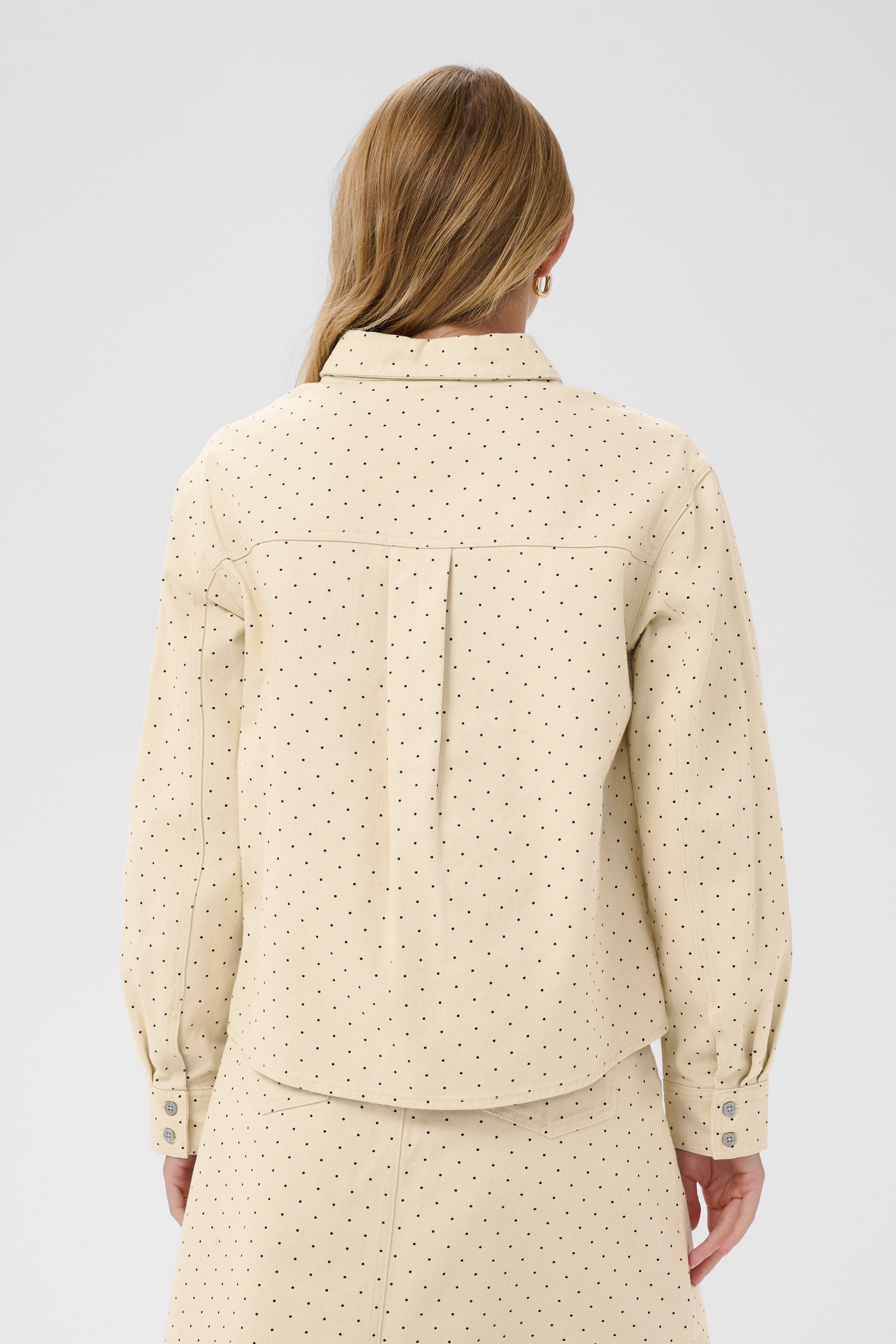Woman wearing the Saint Tropez Patricia beige polka dot shirt