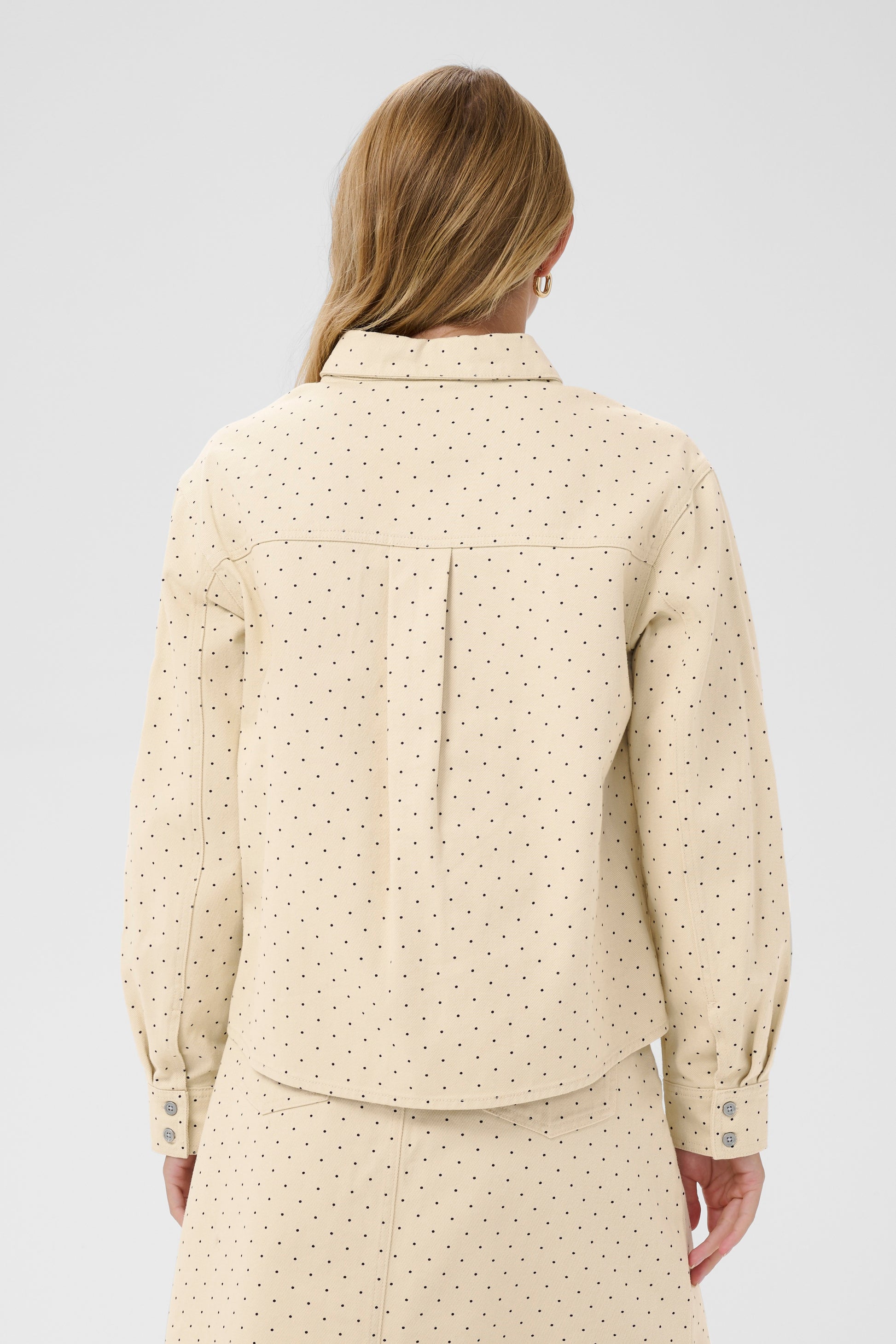 Woman wearing the Saint Tropez Patricia beige polka dot shirt