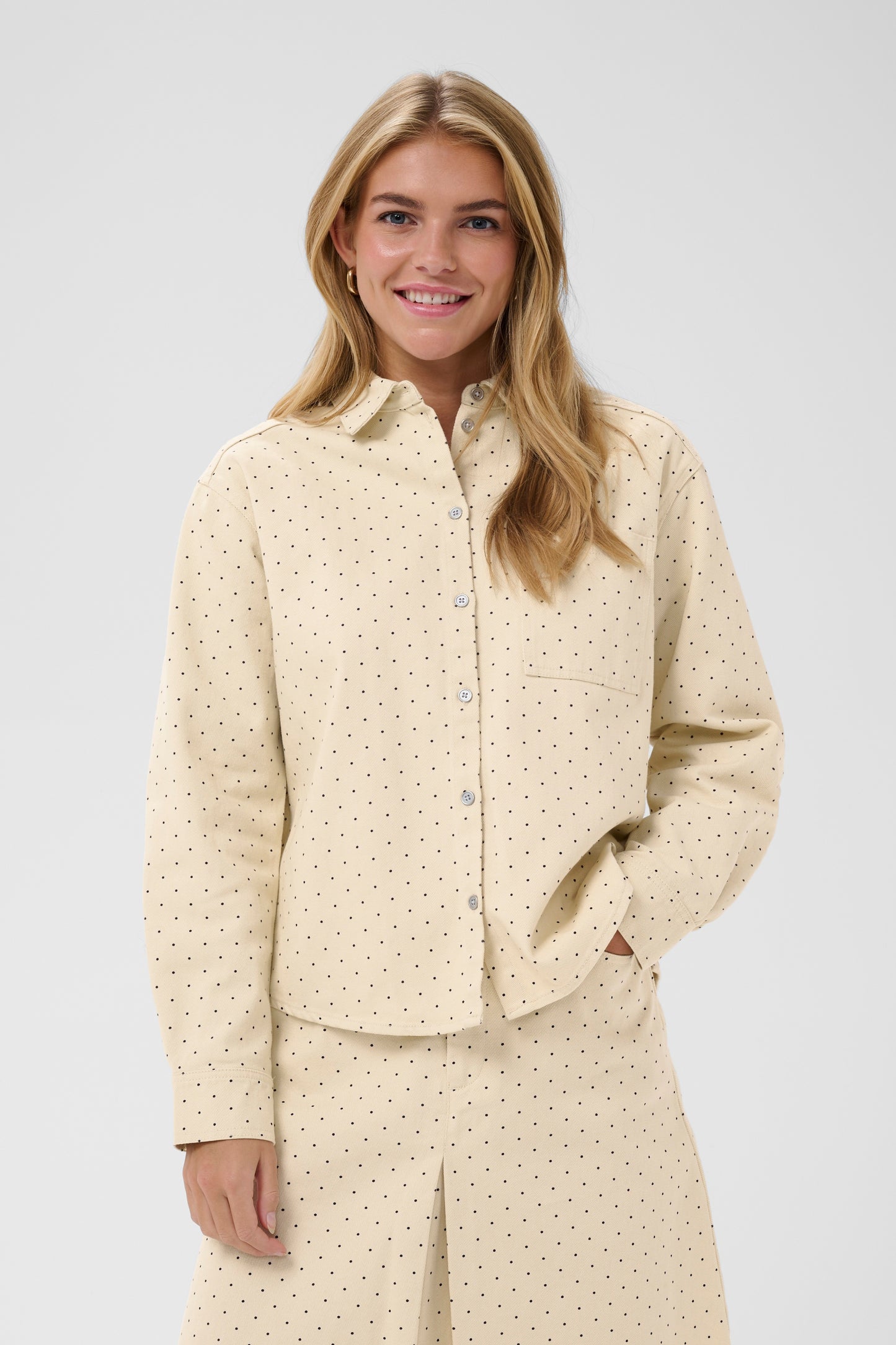 Woman wearing the Saint Tropez Patricia beige polka dot shirt